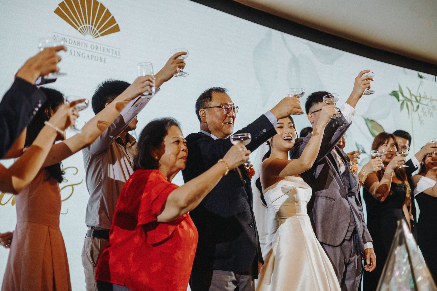 Wedding guests raising their arms in unison during a celebratory moment.