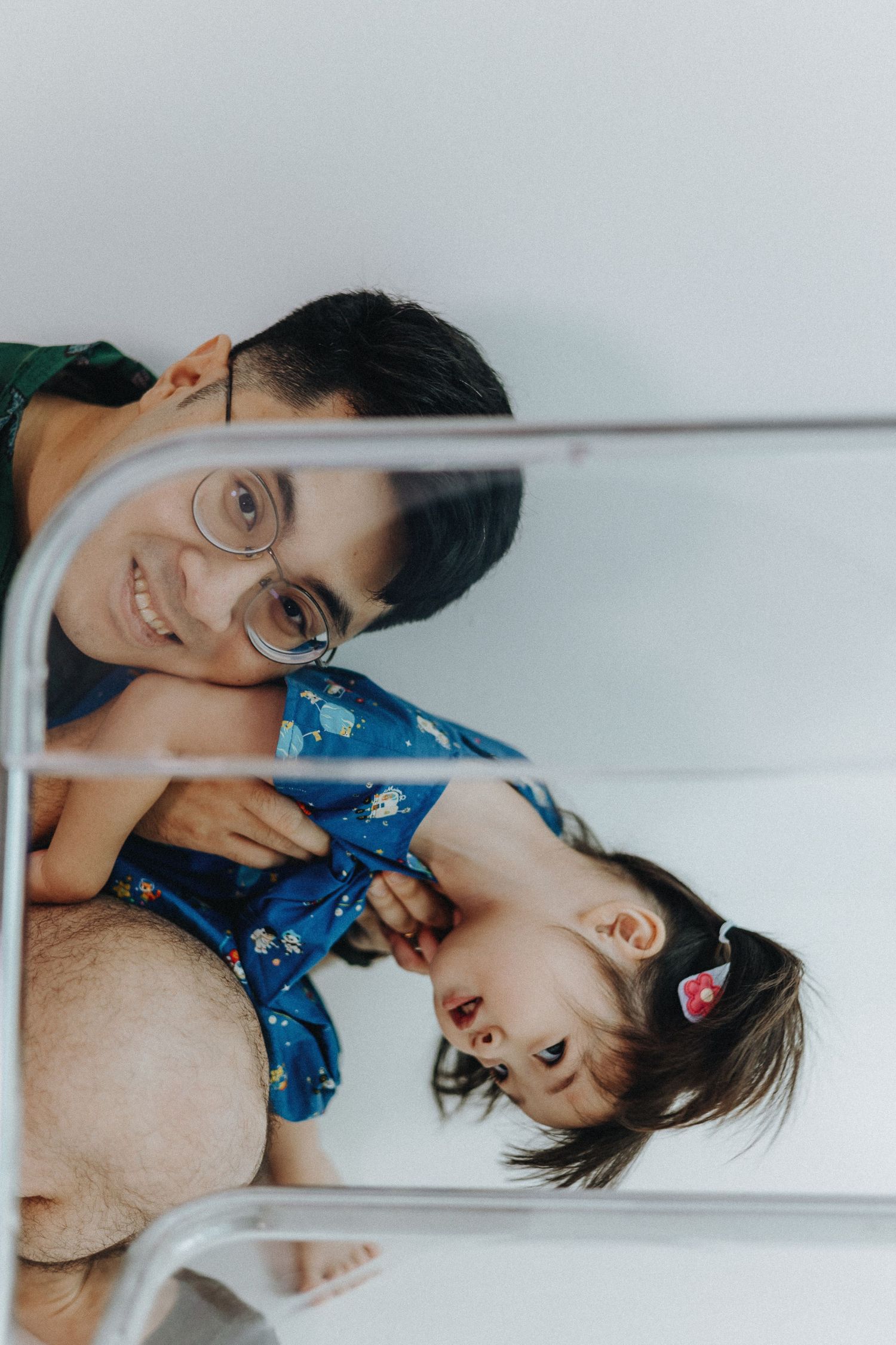 Creative angle mirror shot capturing playful family interaction.
