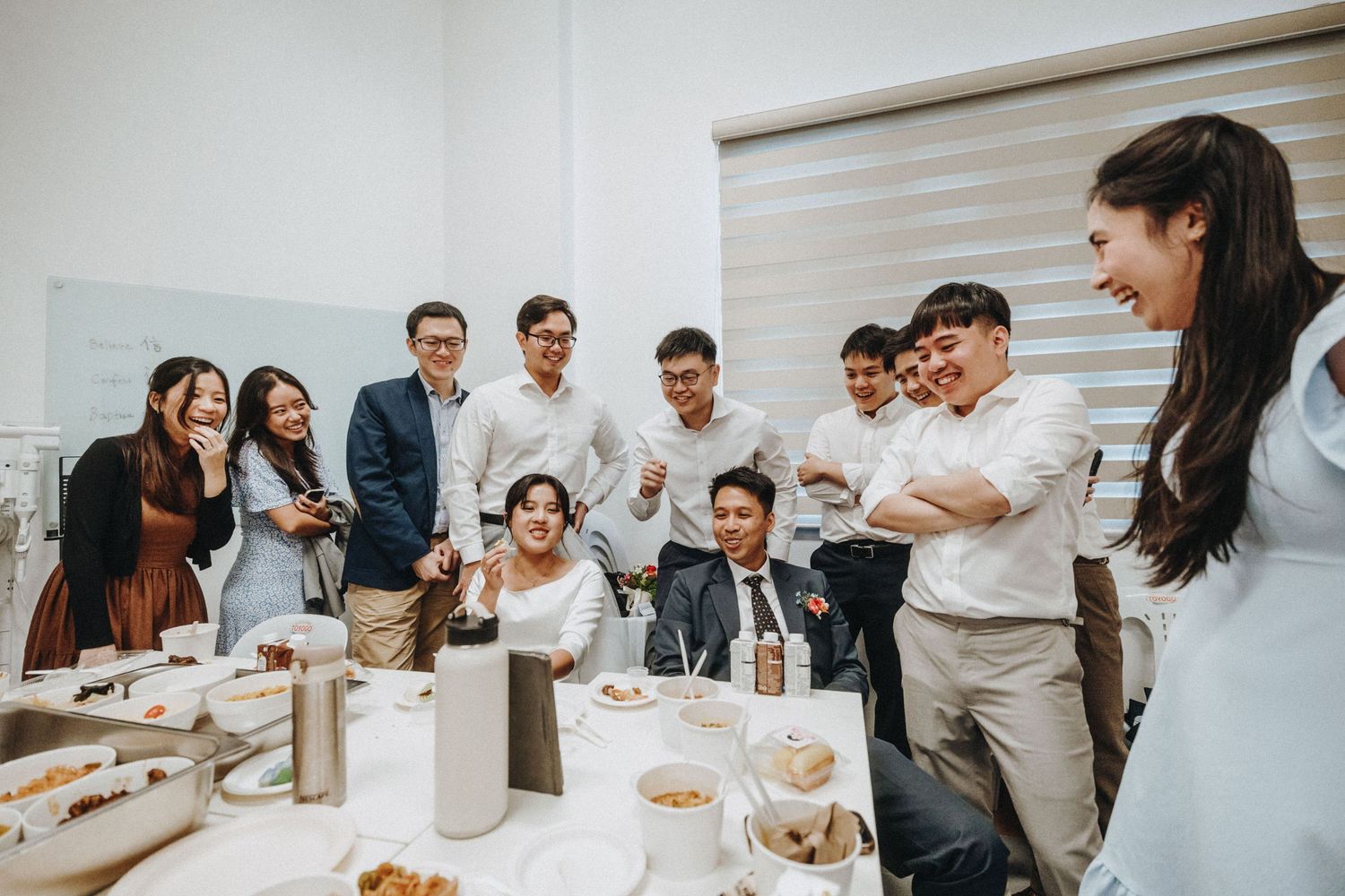 Wedding guests laughing and celebrating together at reception table.