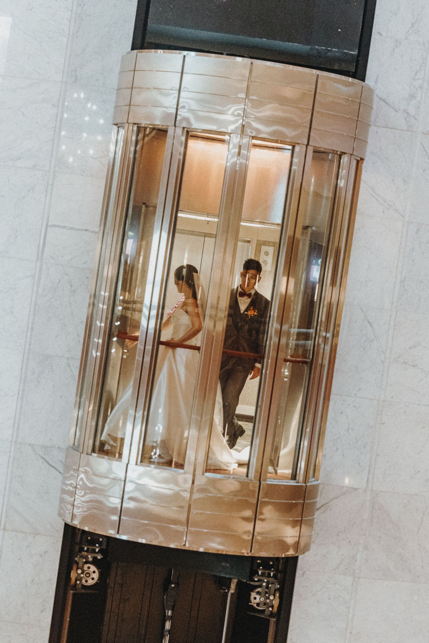 Modern glass revolving doors in a marble lobby showing reflections and architectural elegance.