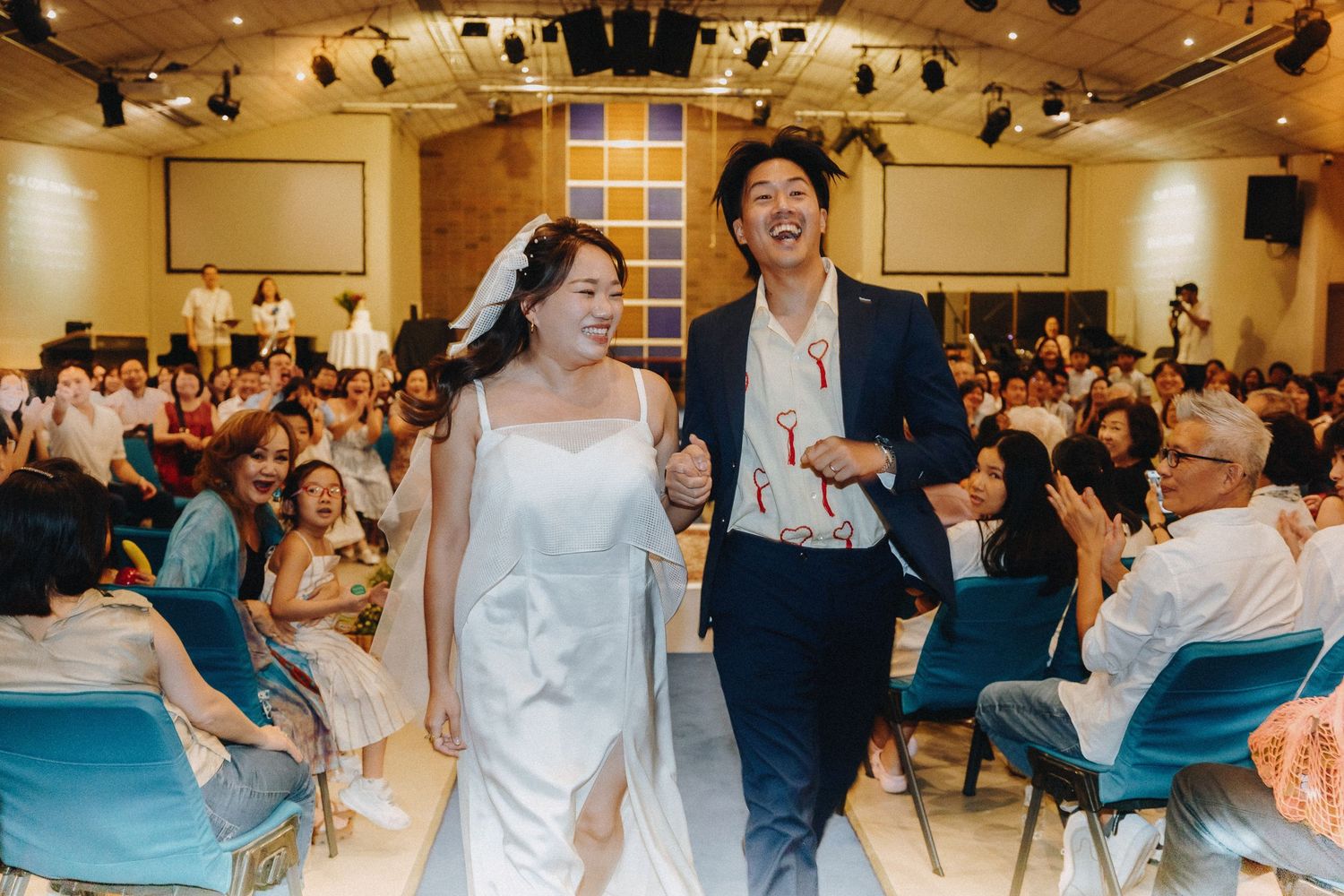 Happy couple walking down aisle together after wedding ceremony.