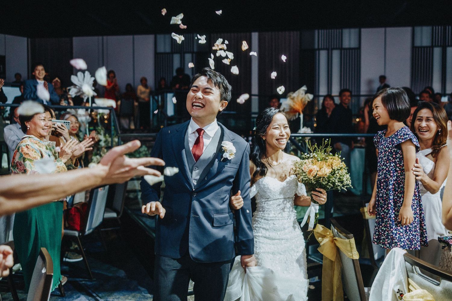Wedding celebration with confetti and joyful guests in modern indoor venue during reception.