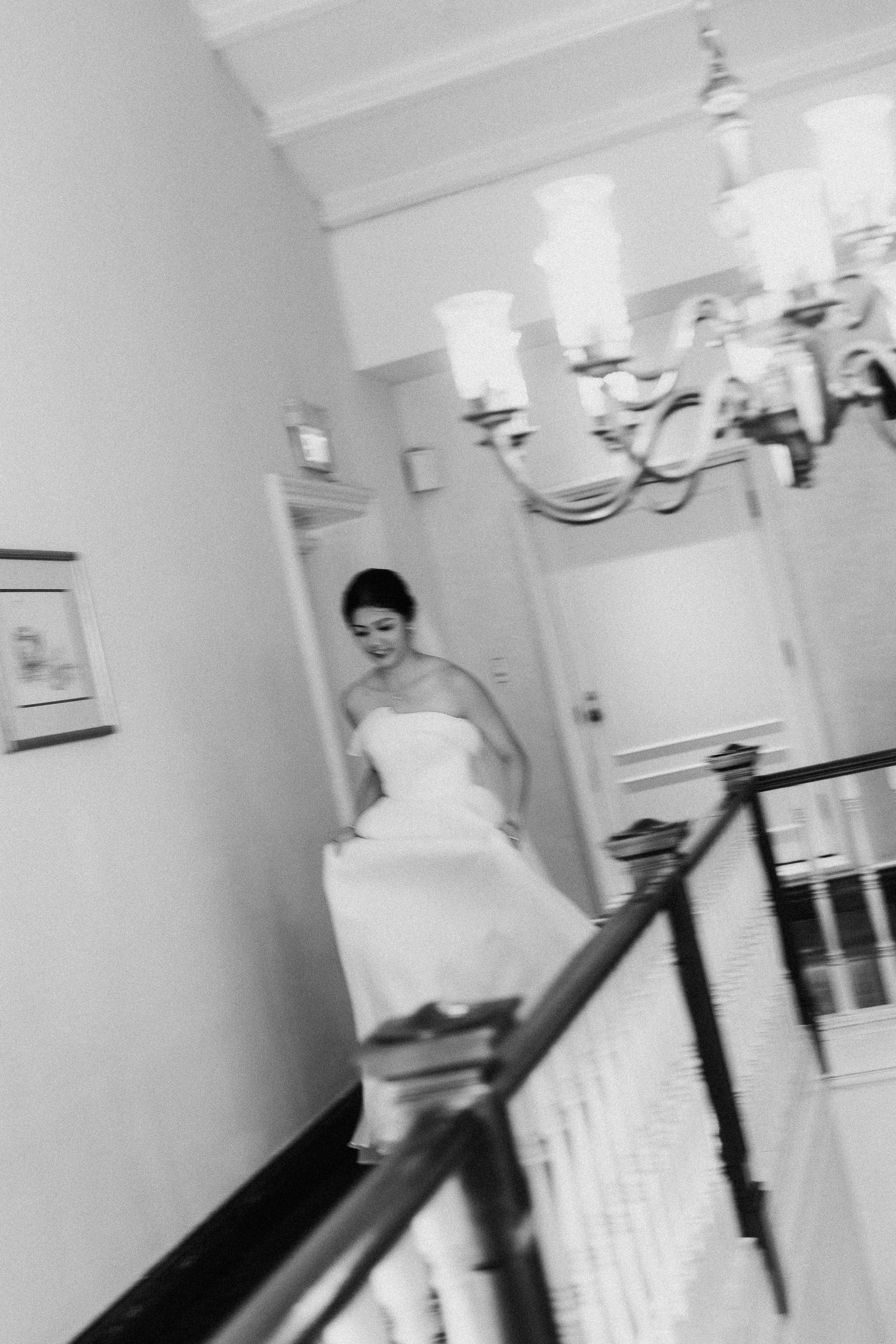 A couple walks down an elegant hallway at a wedding venue with classic decor and lighting.