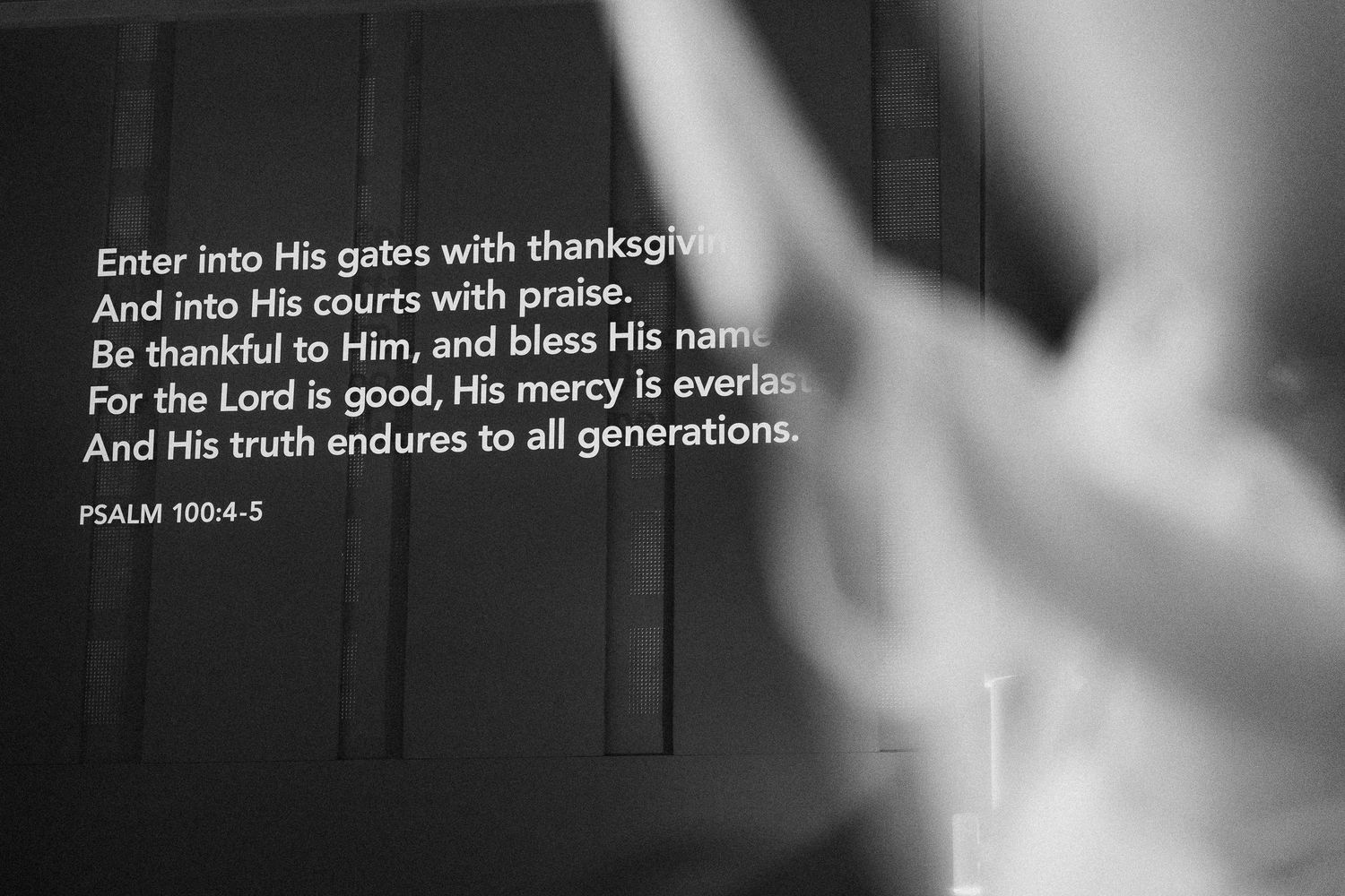 Bible verse from Psalm 100 displayed in white text against a dark background.