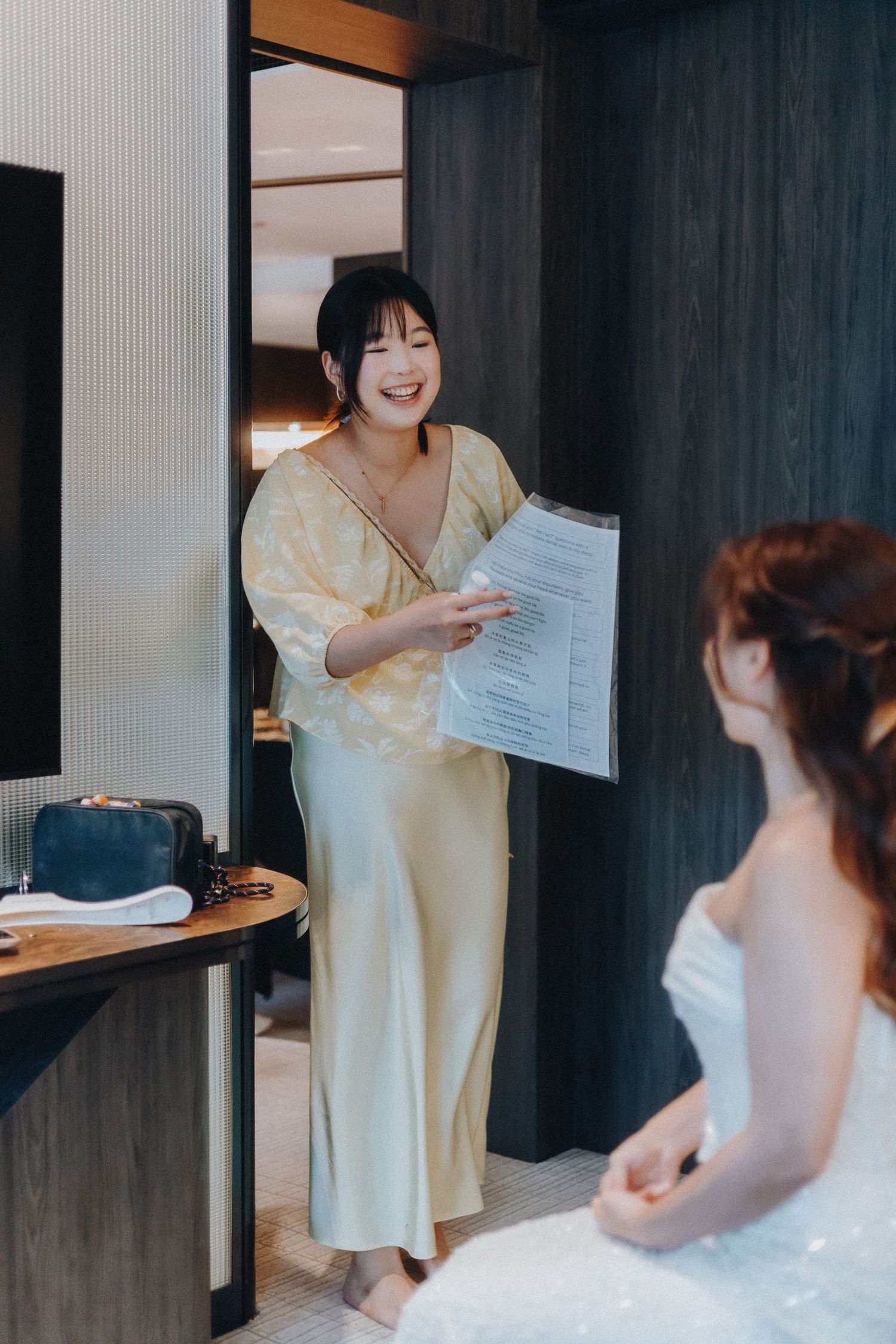 Wedding couple shares an emotional moment while reading letters to each other in a hotel room.