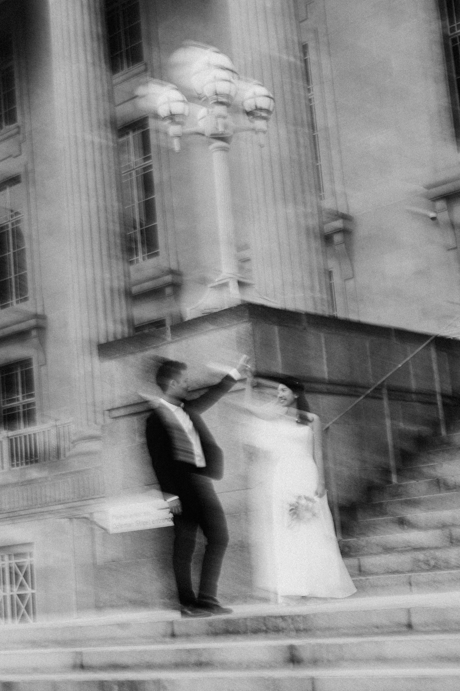 Motion-blur black and white wedding photos captured on classical architecture steps showing dynamic movement.