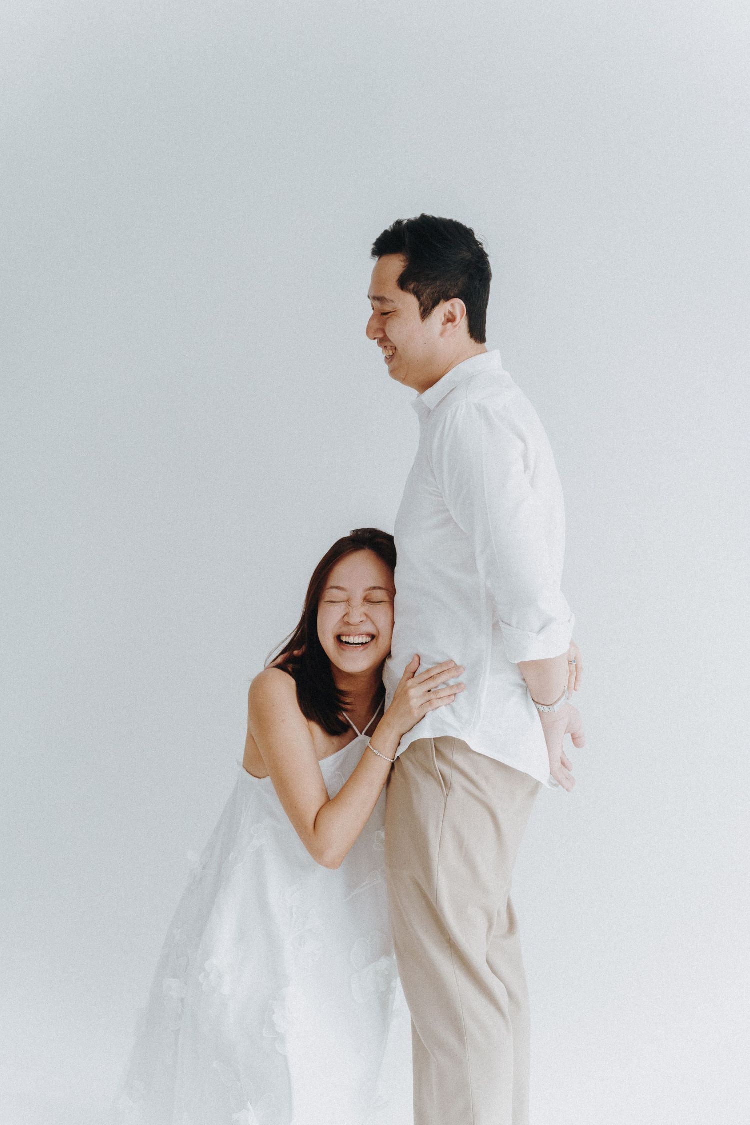 A couple shares playful moments against a white background in a series of romantic lifestyle photos.