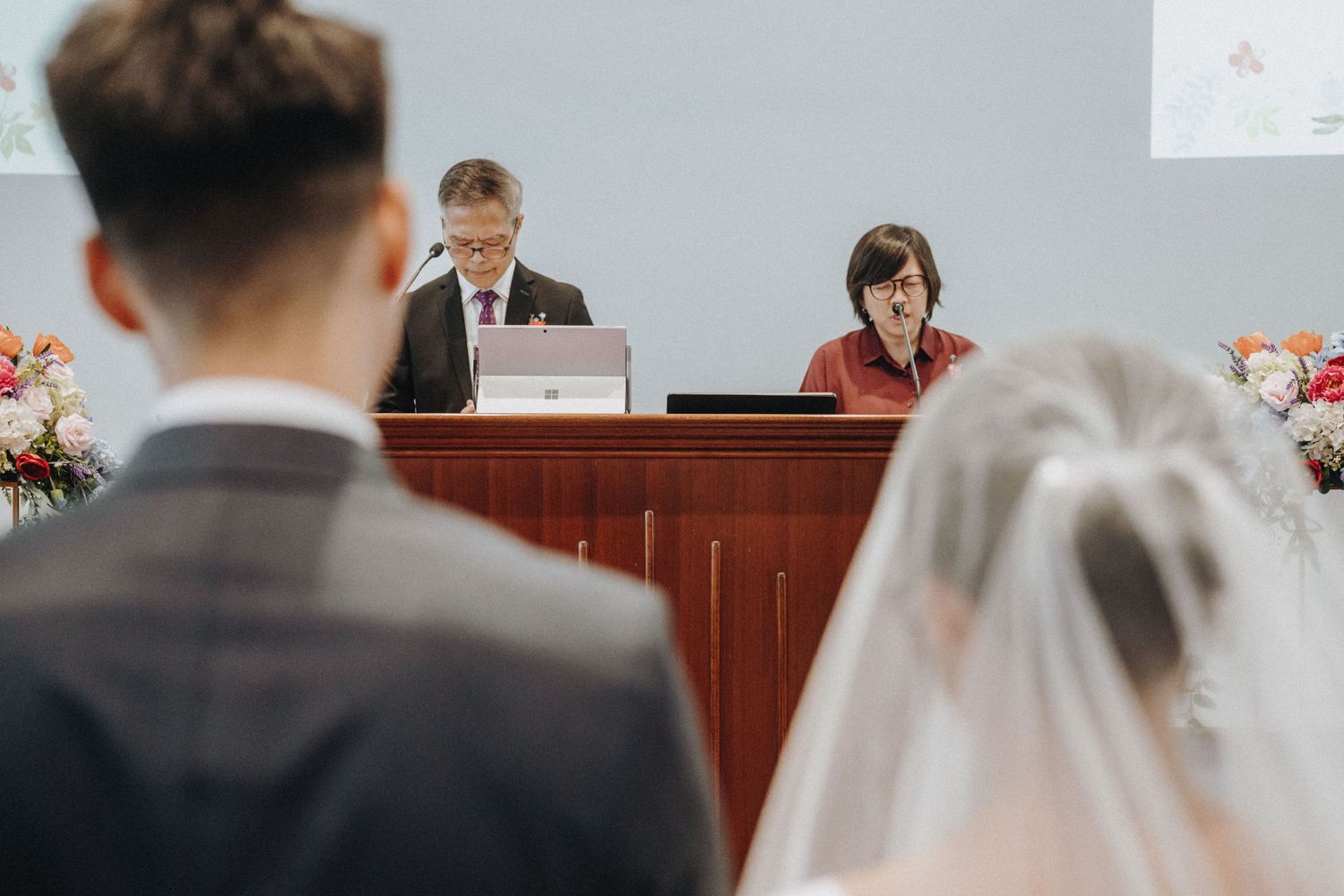 Bride and groom standing before officiant during wedding ceremony.
