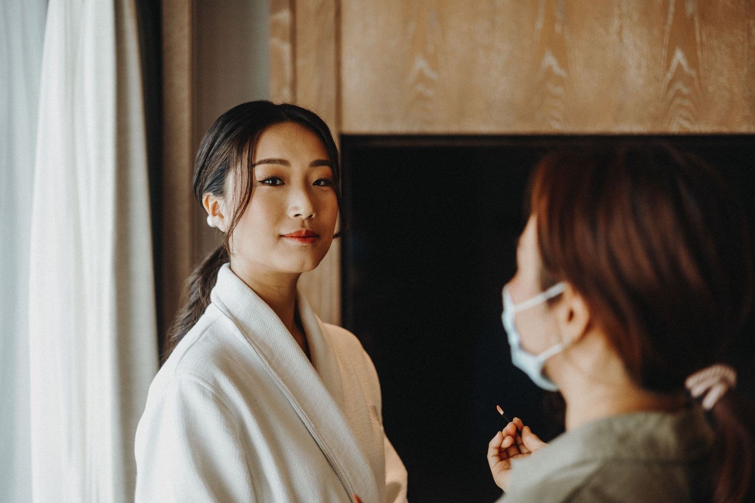 Close-up view of a bride's glam getting ready with delicate makeup being applied.