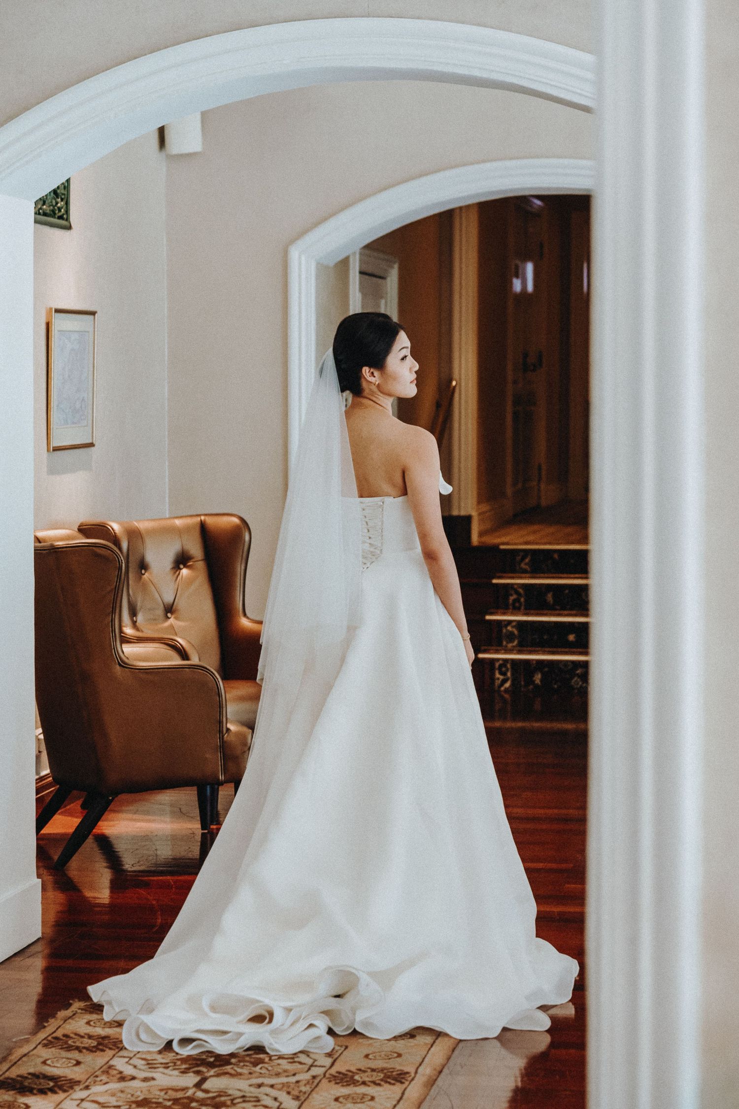 White wedding dress details shown in segments through curved architectural arches in an elegant interior.