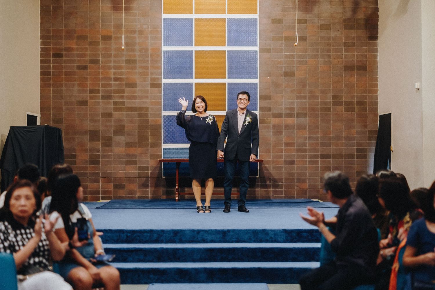 Church interior with orange and purple geometric wall decorations and brick walls.