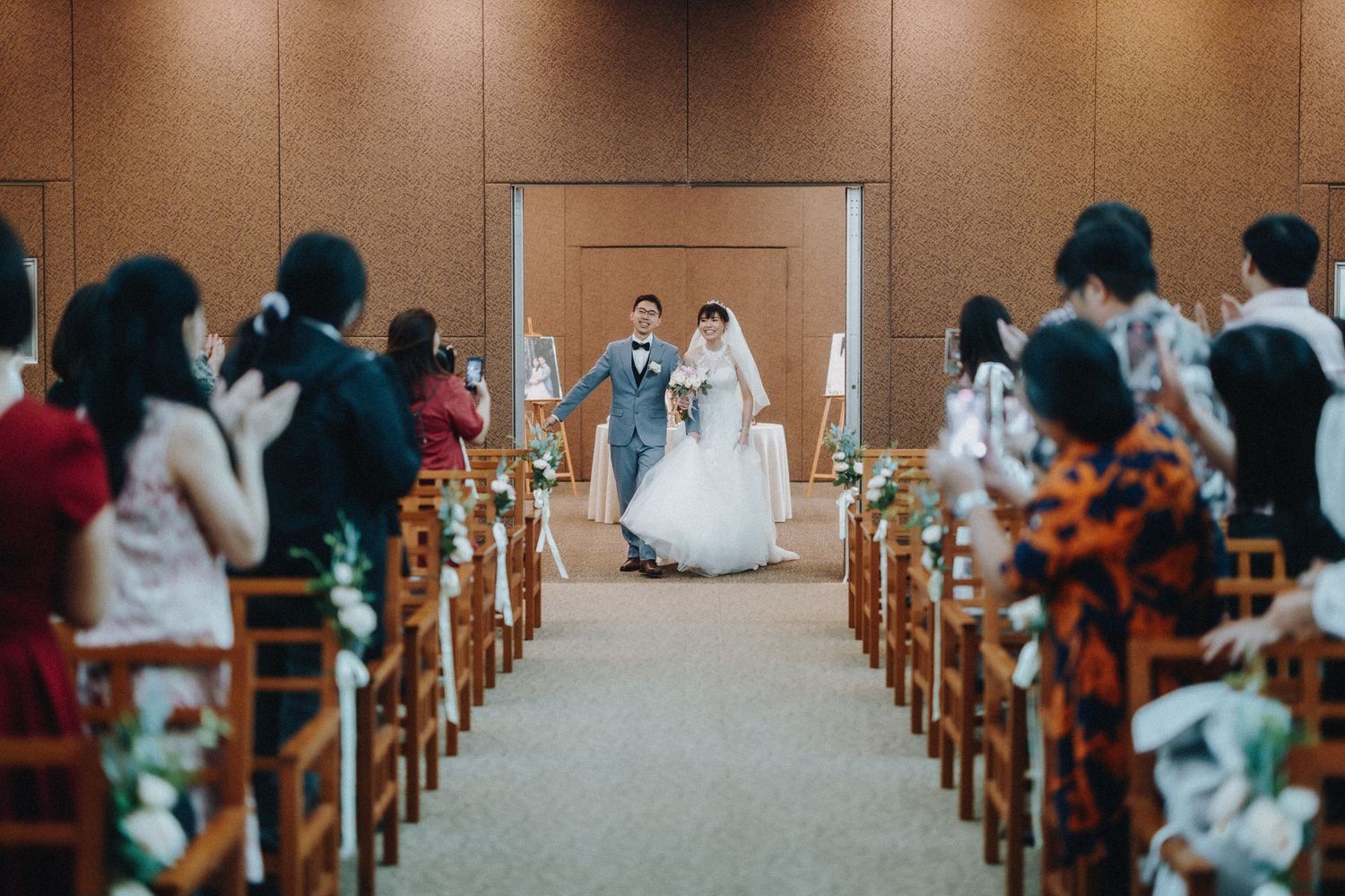 Traditional church interior with wooden pews and decorative floral arrangements along the aisle.