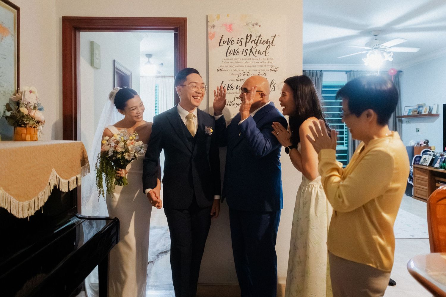 Joyful wedding celebration with bride and groom sharing a happy moment with family guests indoors.