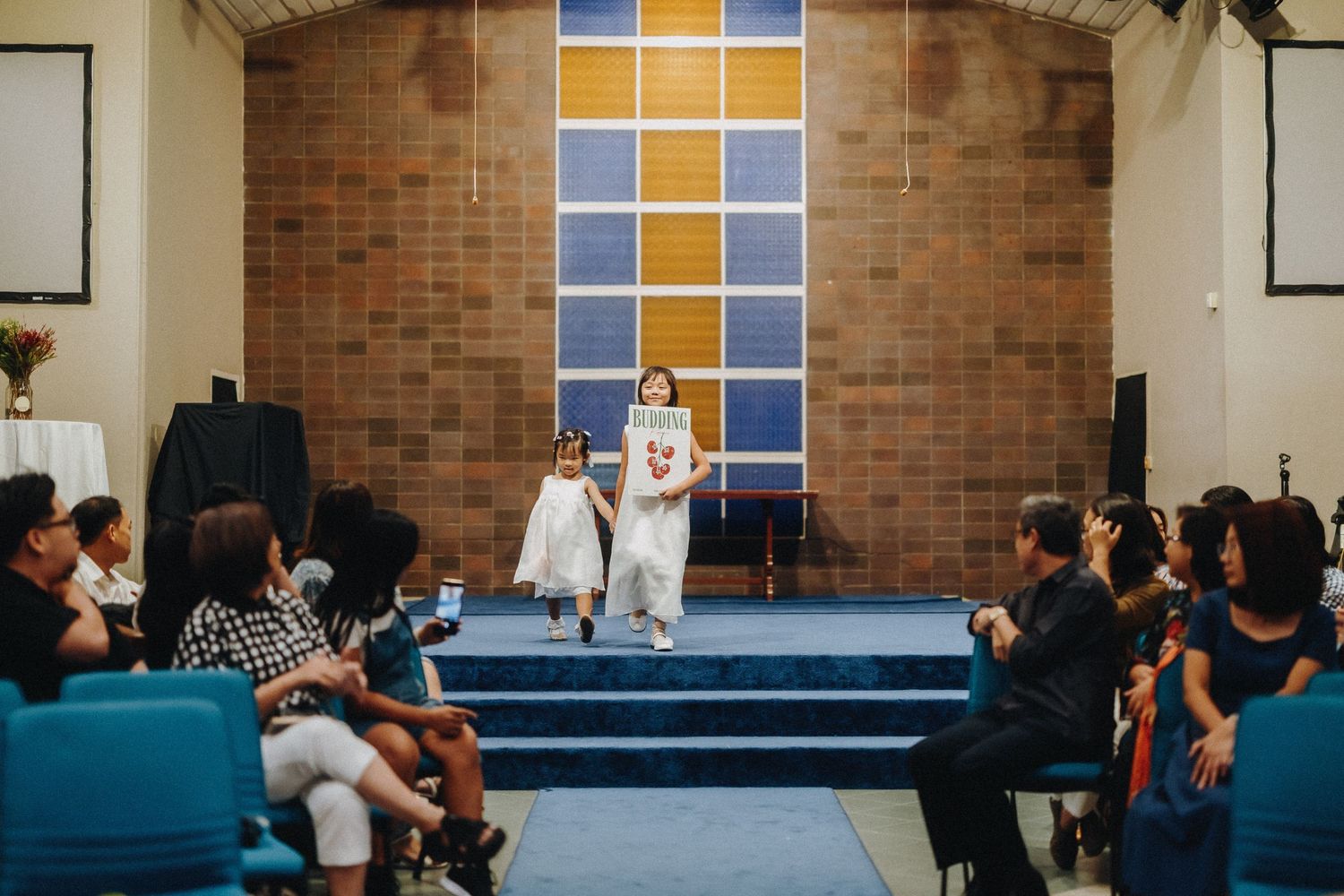 Wedding ceremony in progress at a church with brick walls and stained glass windows.