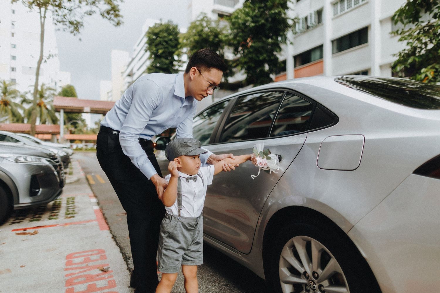 A car grooming scene in an outdoor parking area on a sunny day.