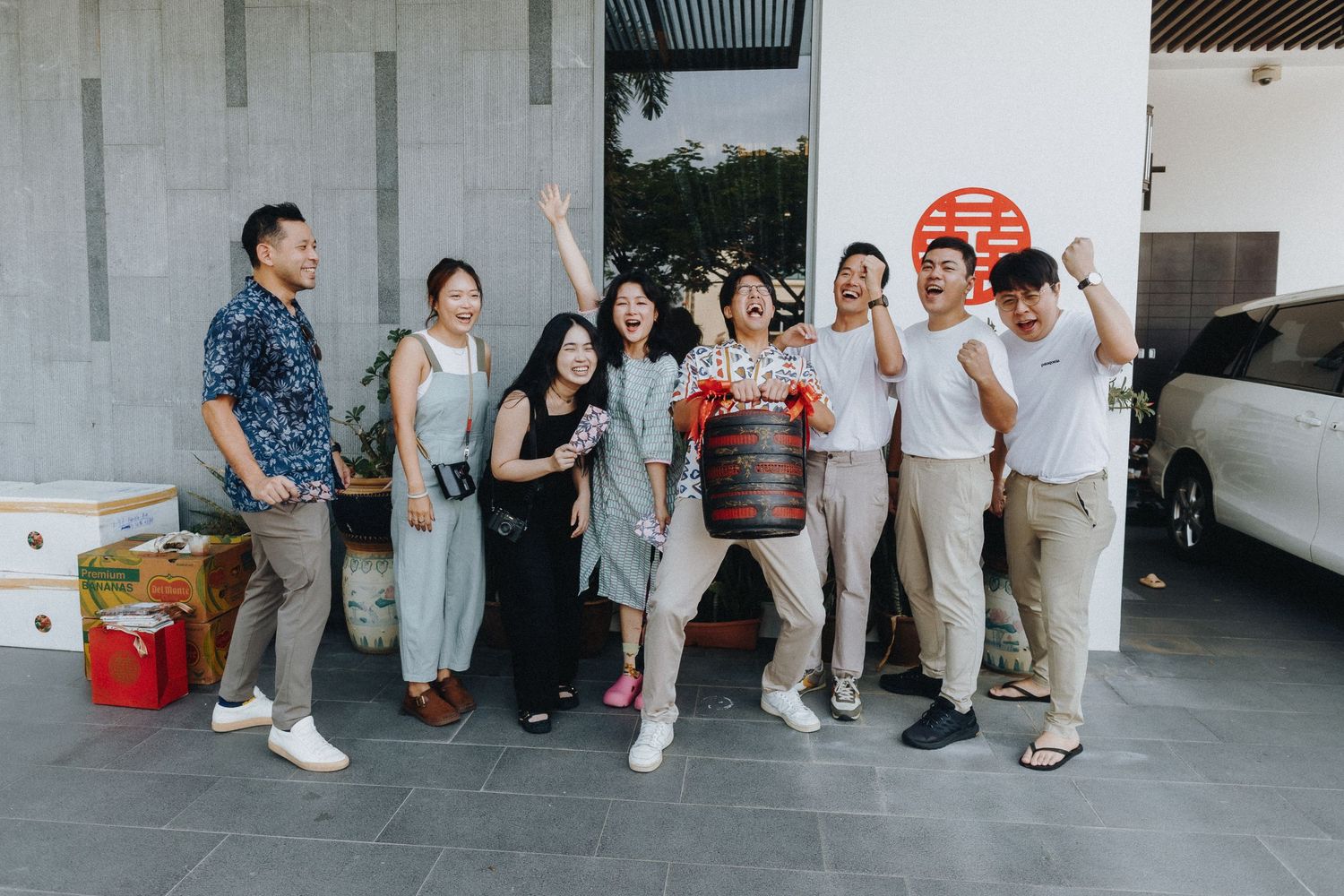 People standing in a line against a white wall waiting for an event.