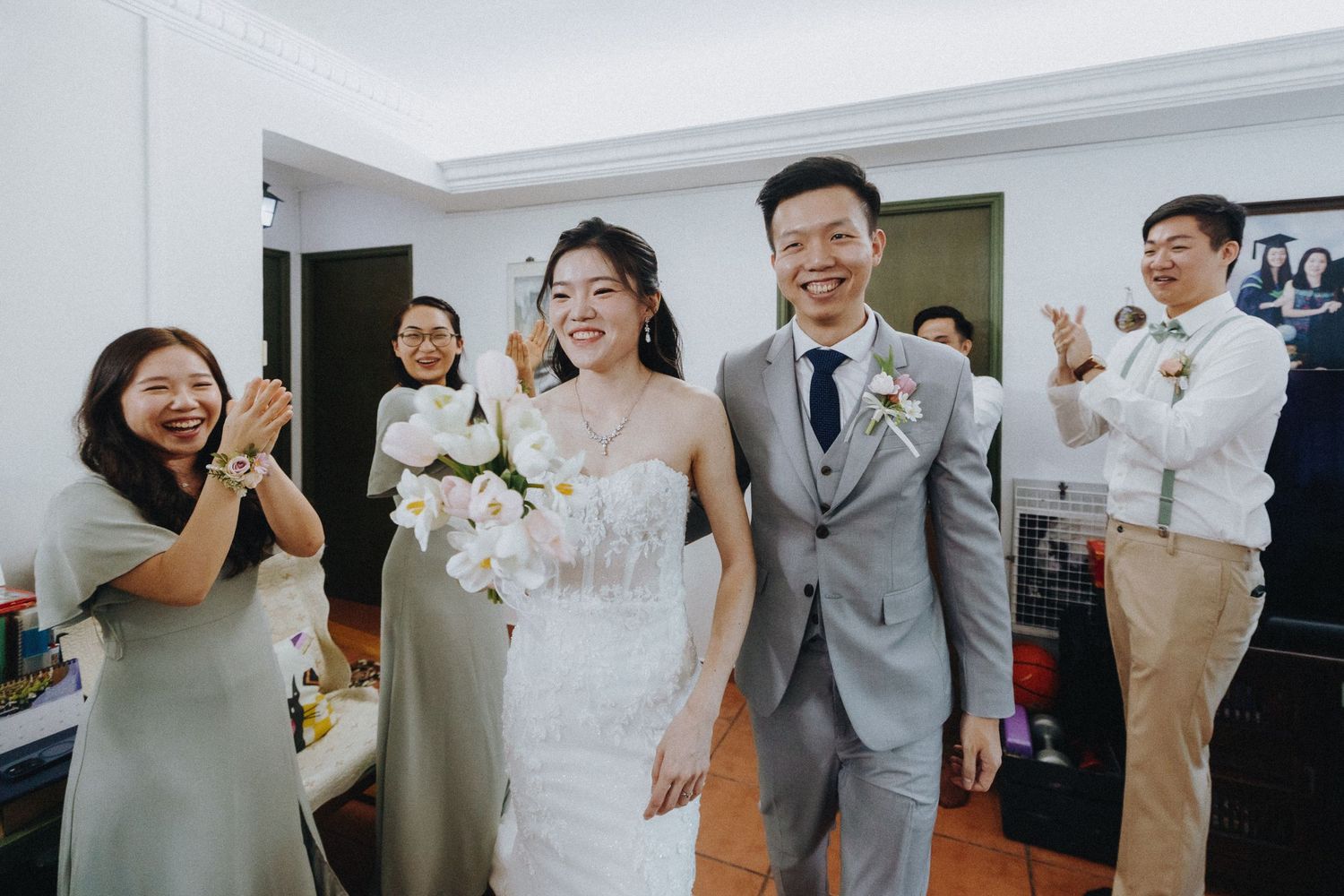 Wedding party sharing laughter and candid moments in bright indoor venue.