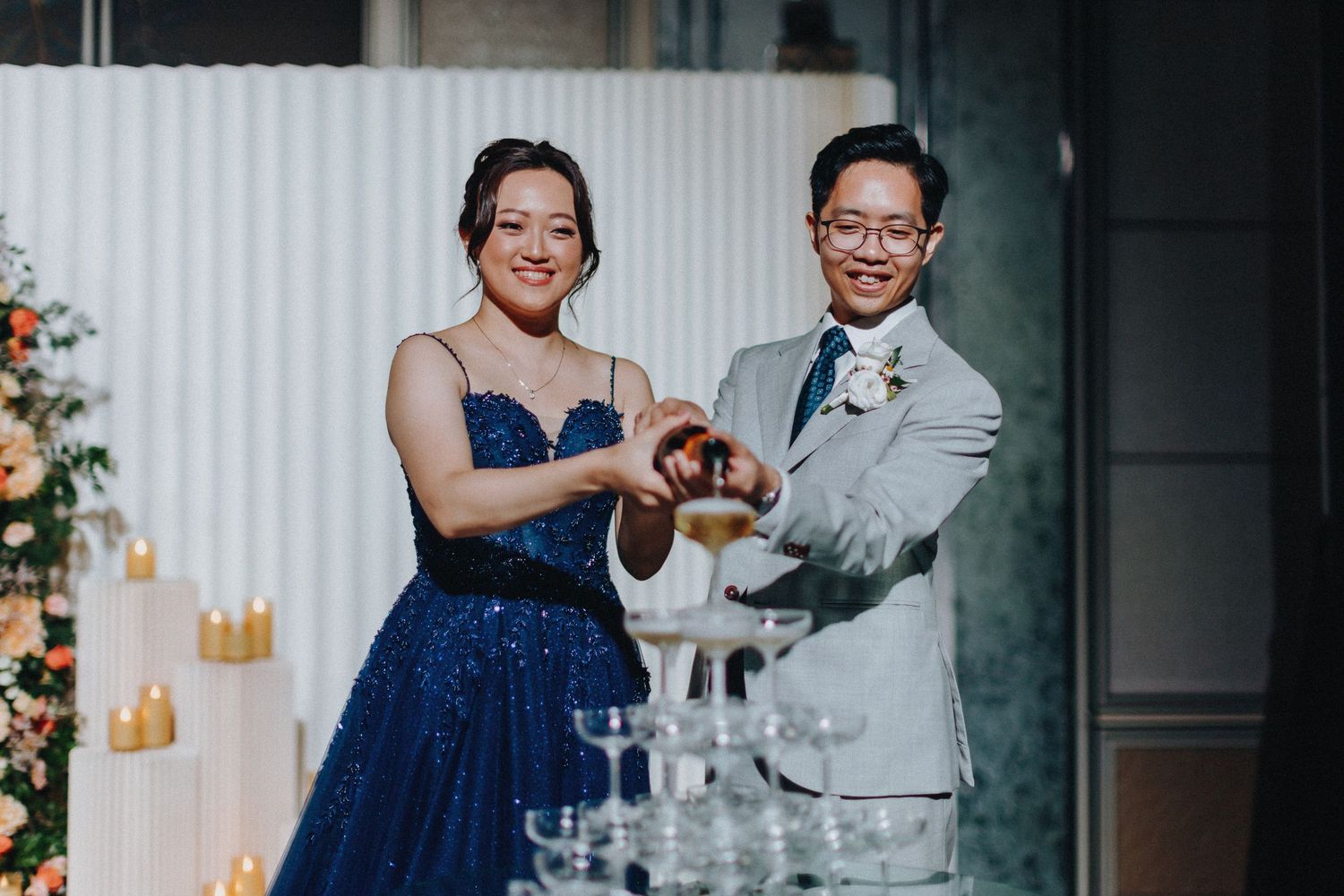 Wedding couple performing champagne toast during reception celebration.