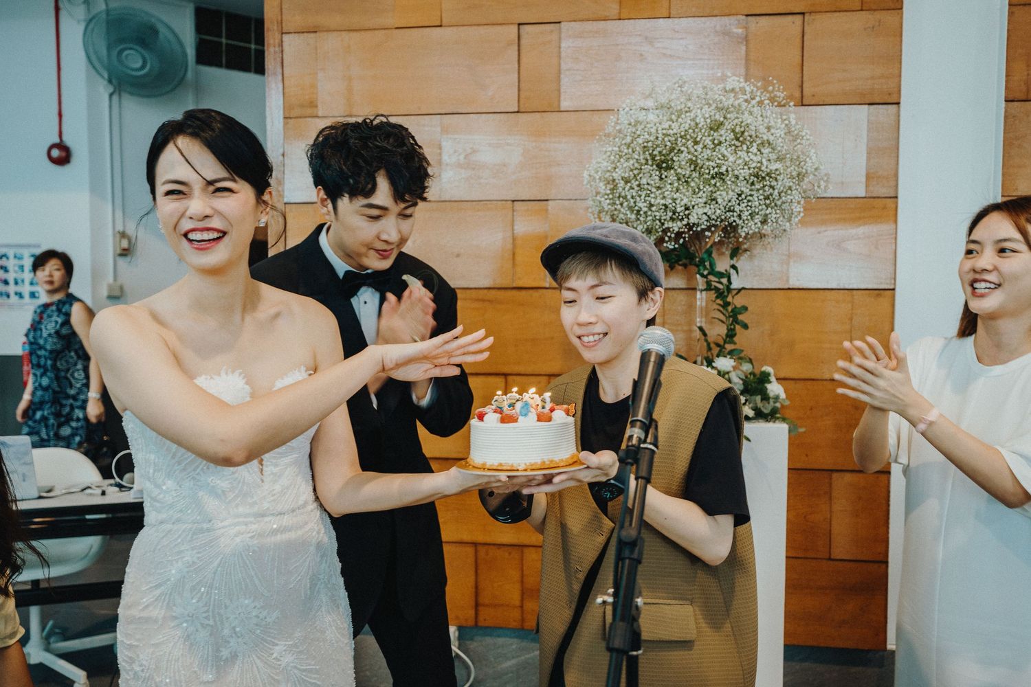 Wedding celebration in venue with wood paneled walls and festive atmosphere.