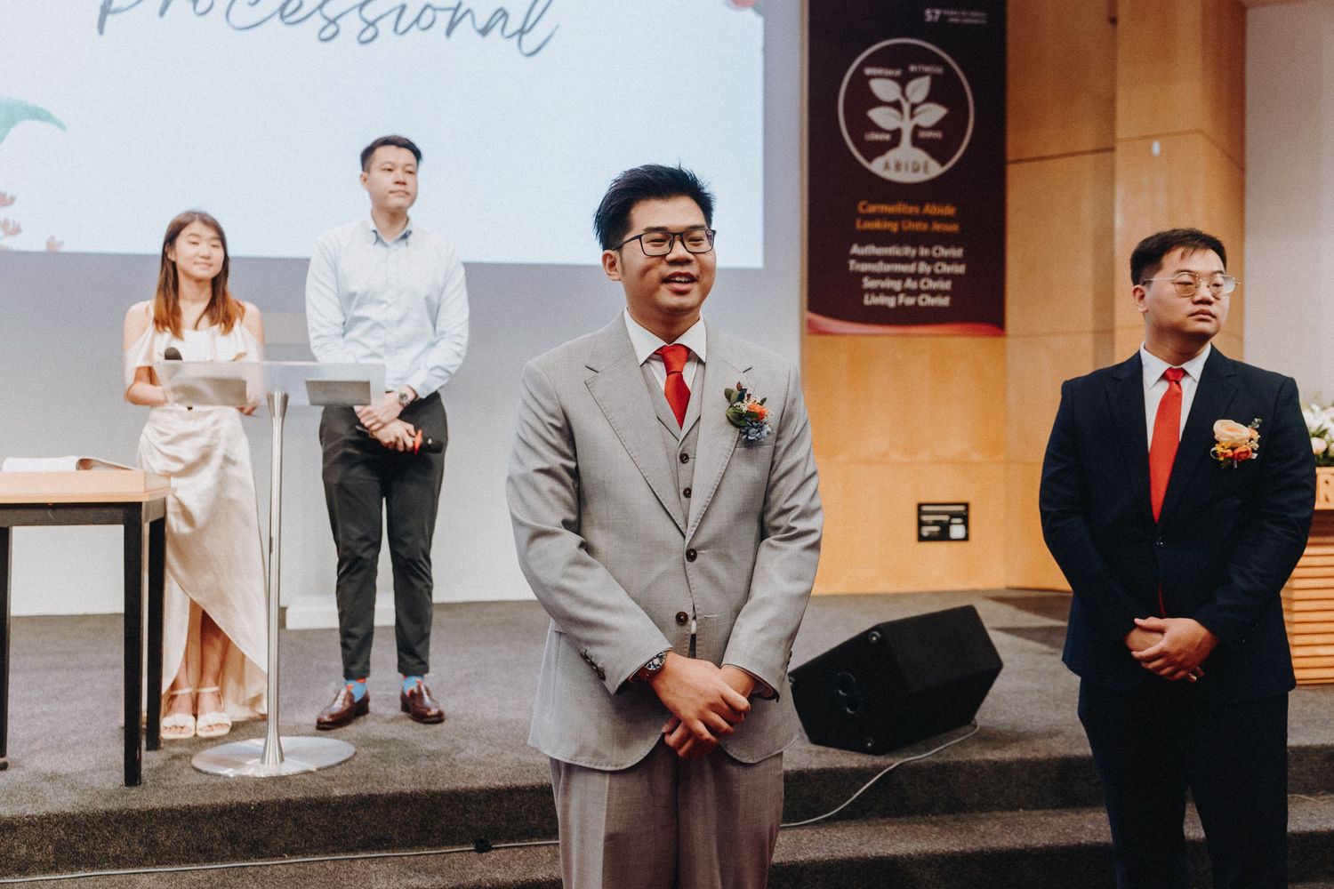 People in formal attire standing together at an event or gathering.