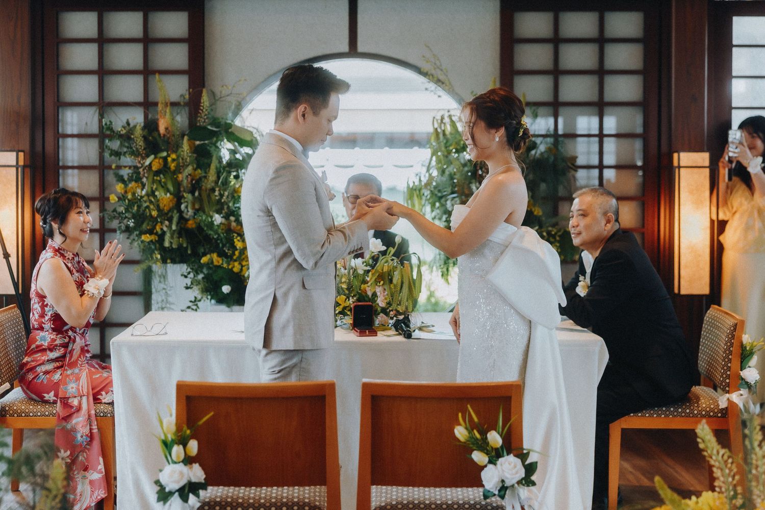 Wedding venue decorated with traditional Asian elements and natural light streaming through windows.