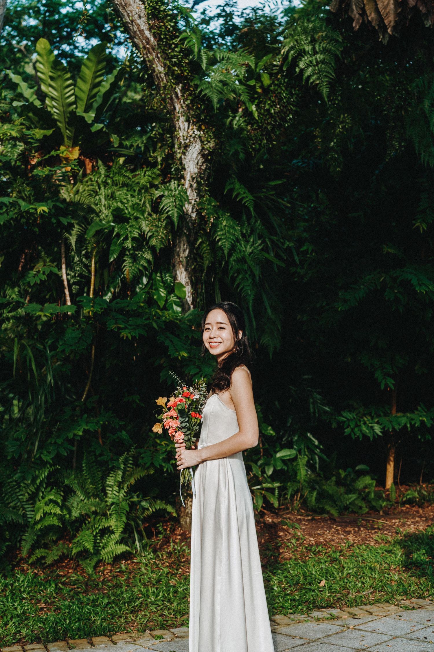 A series of candid shots in a garden setting showing someone in a flowing white dress holding colorful flowers.