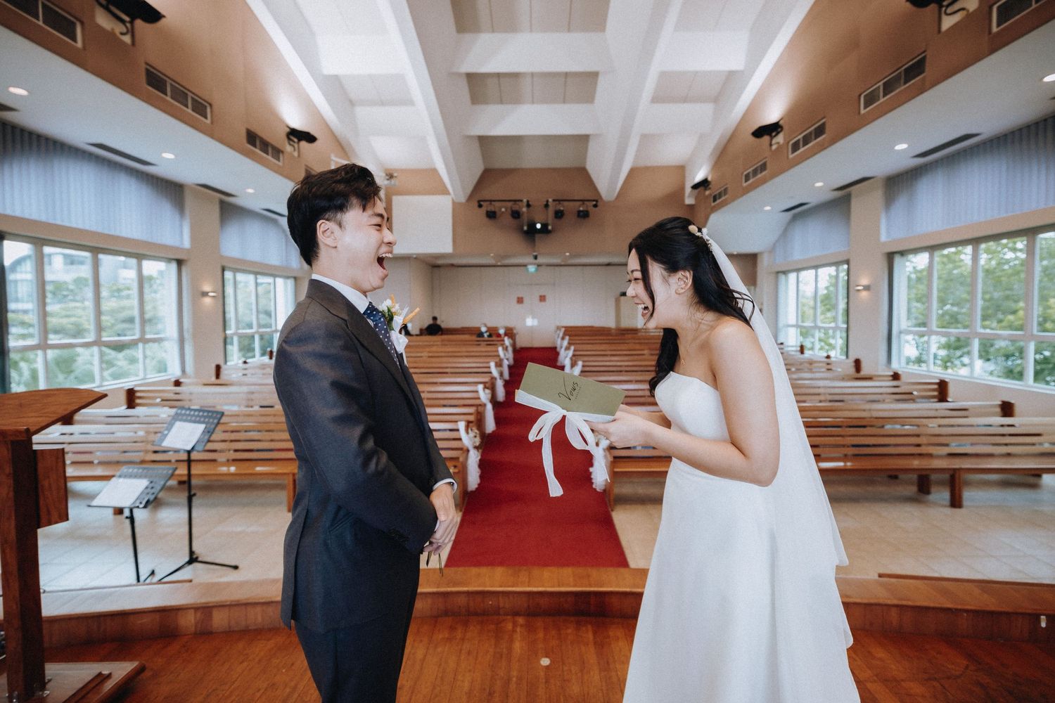 Bride and groom share a joyful moment at the church altar during their wedding ceremony.