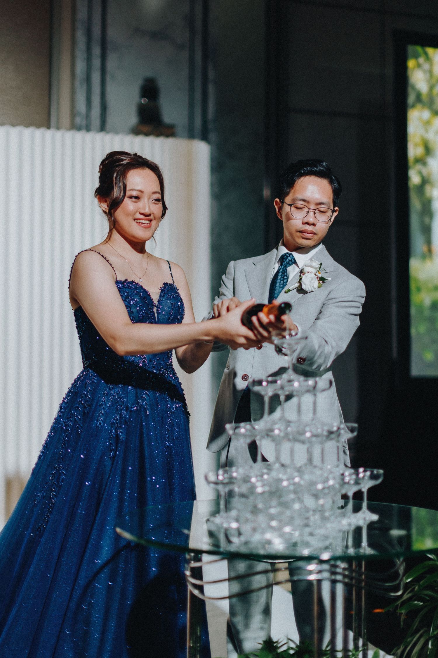 A formal celebration moment near a champagne tower with elegant attire.