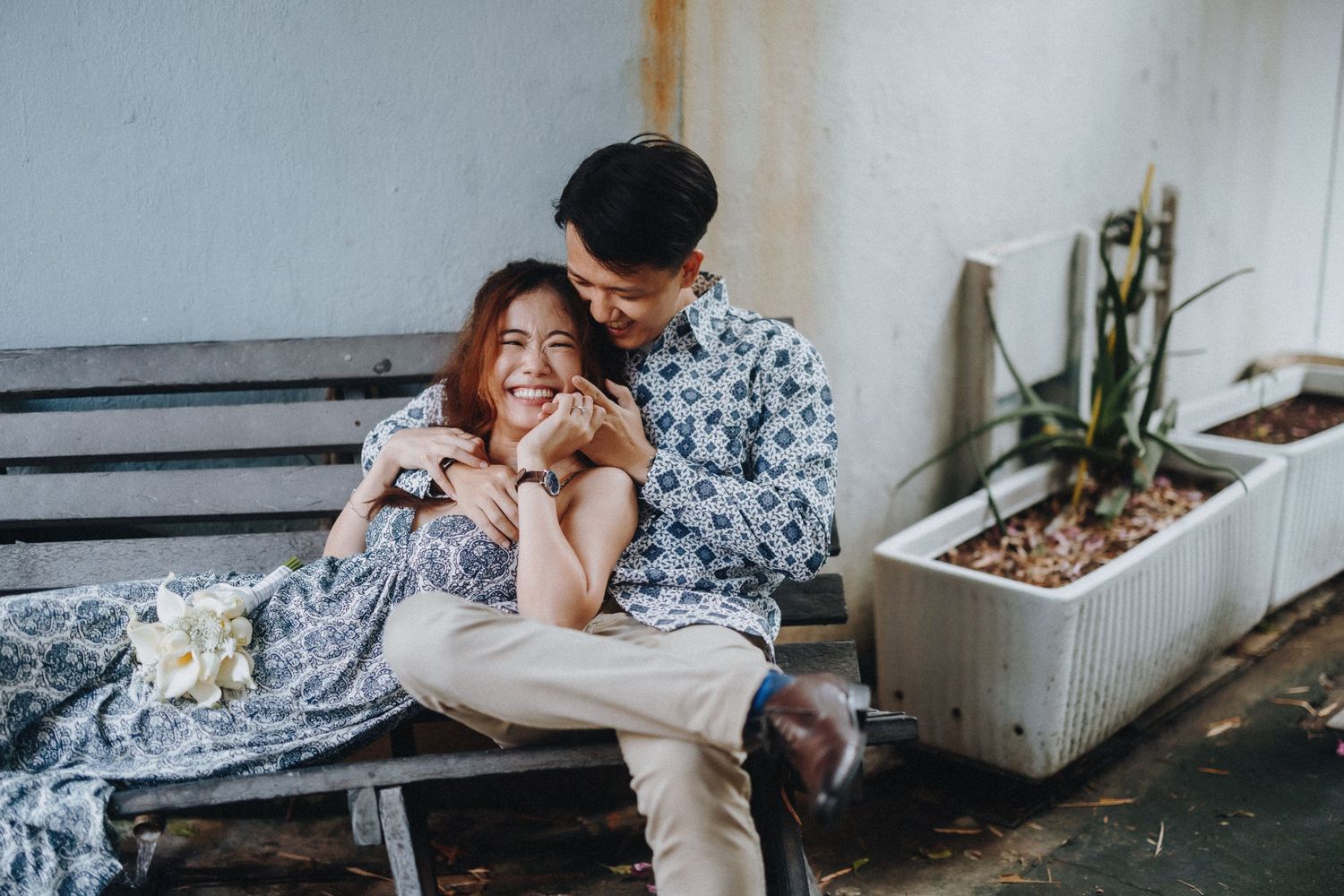 Couple lounging intimately in casual attire on a cozy indoor sofa.