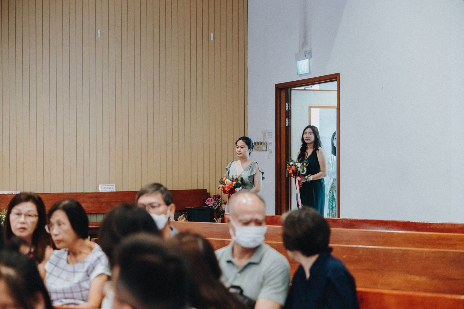 People gathered in wooden pews at a religious or community event watching a performance.