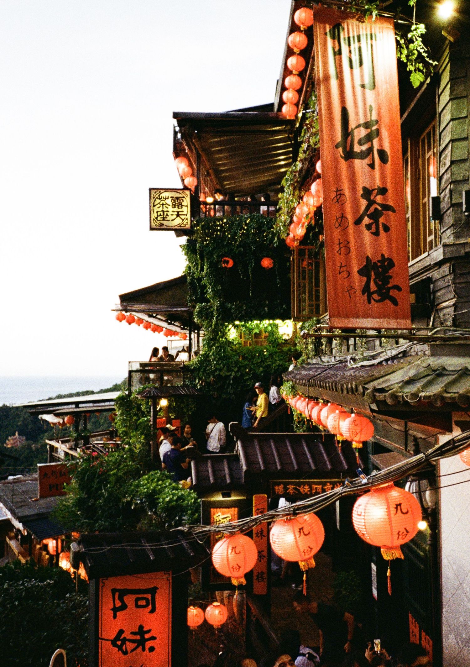 Traditional Japanese street decorated with glowing orange lanterns and historic architecture at night.