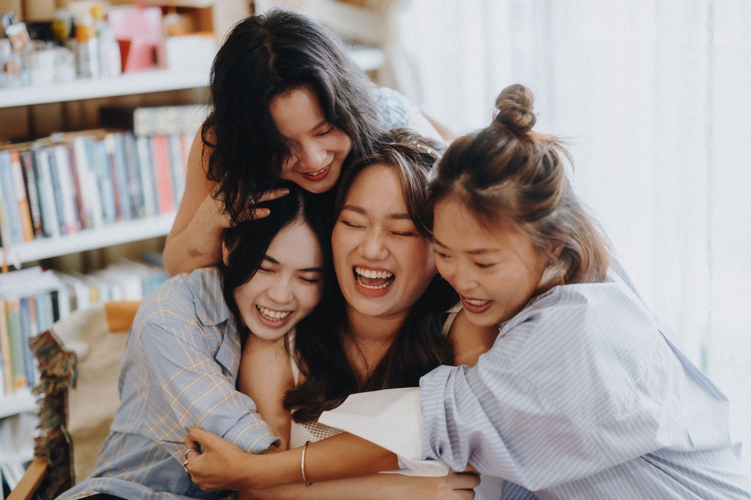 Group of friends sharing joyful moments together in a bright room.