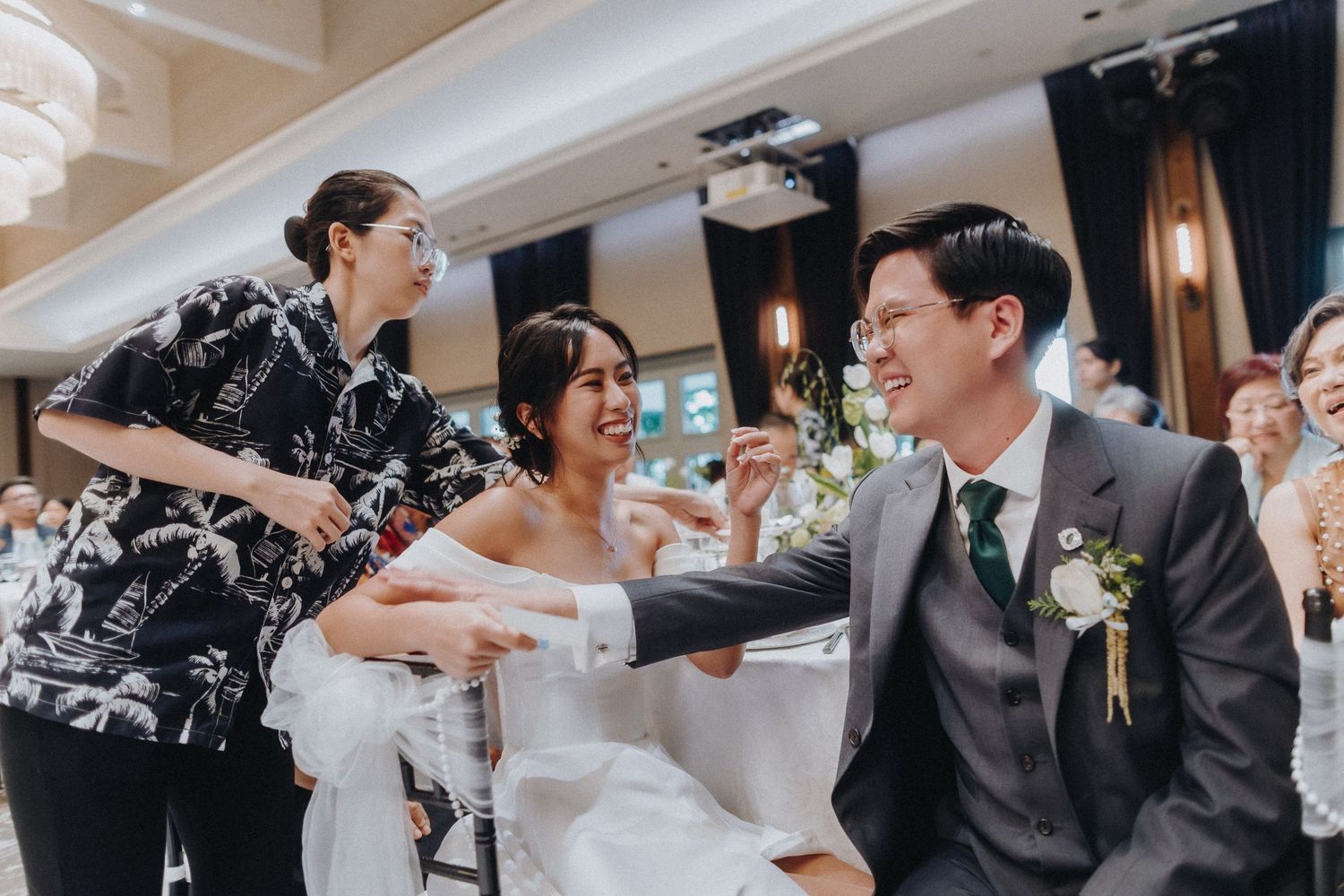 Candid moment of celebration during a wedding reception in an elegant indoor venue.