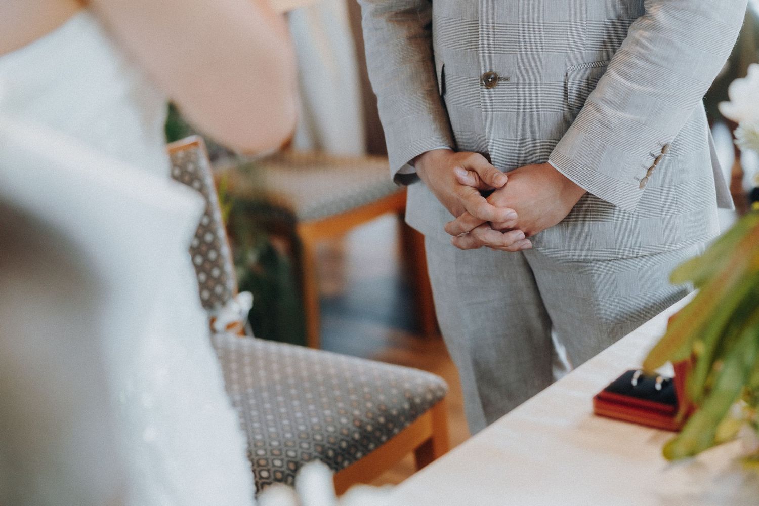 Couple in wedding attire stands together during ceremony in elegant venue.