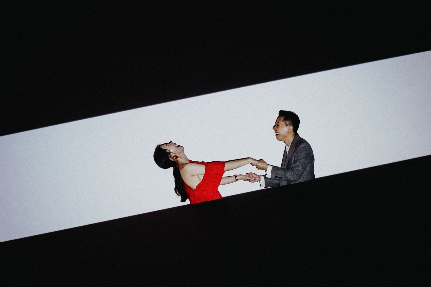 Two people engage in a dramatic dance pose against a stark black and white background.