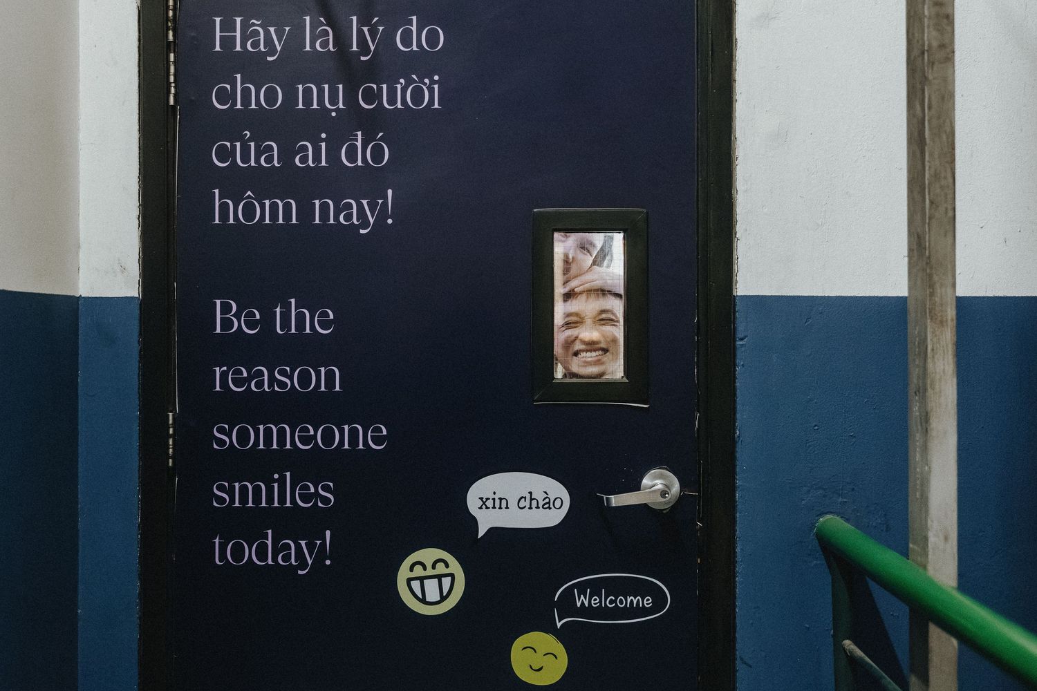 A black and blue wall with text reading 'Be the reason someone smiles today!' and small stickers below.