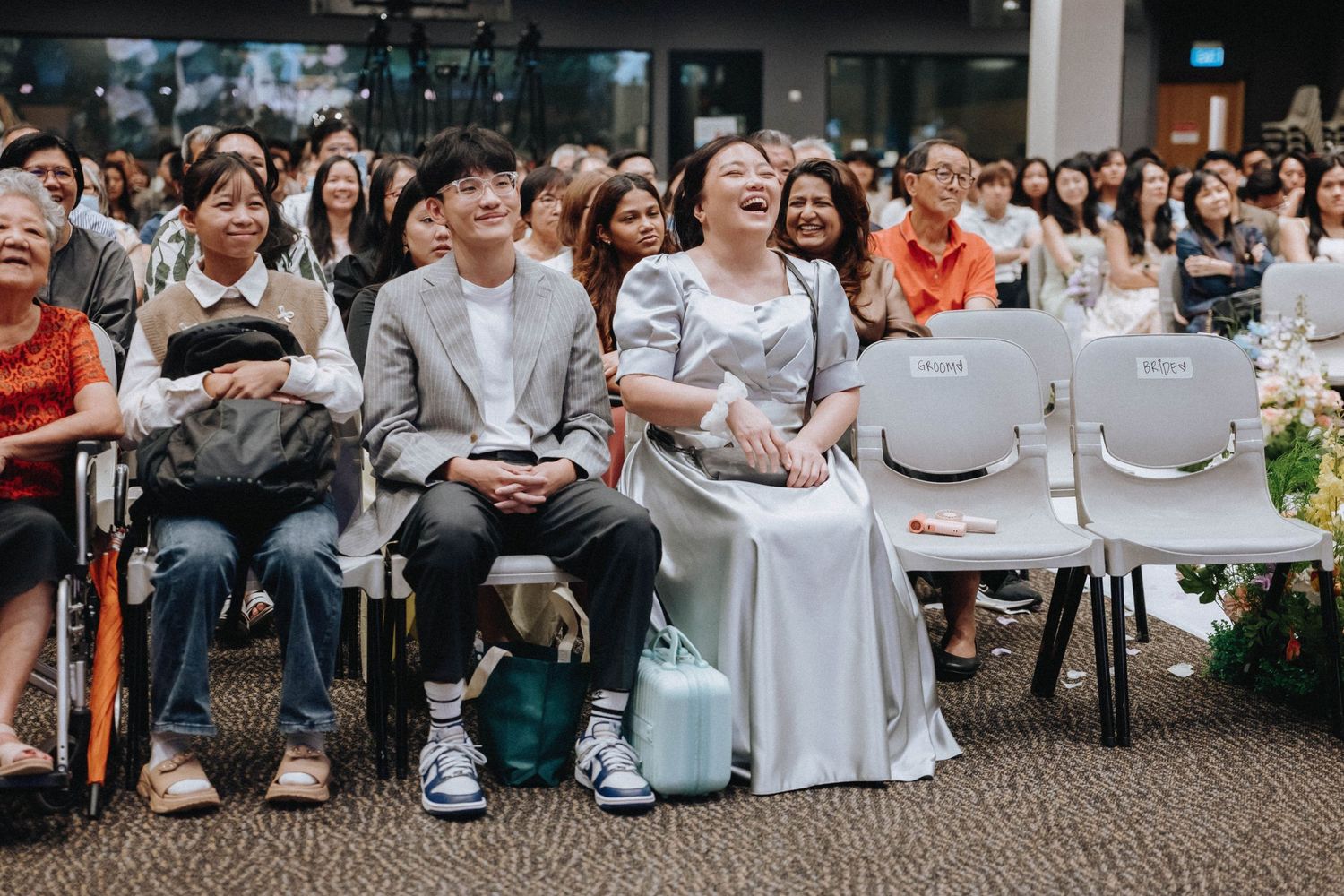 Wedding guests seated at round tables during reception celebration.