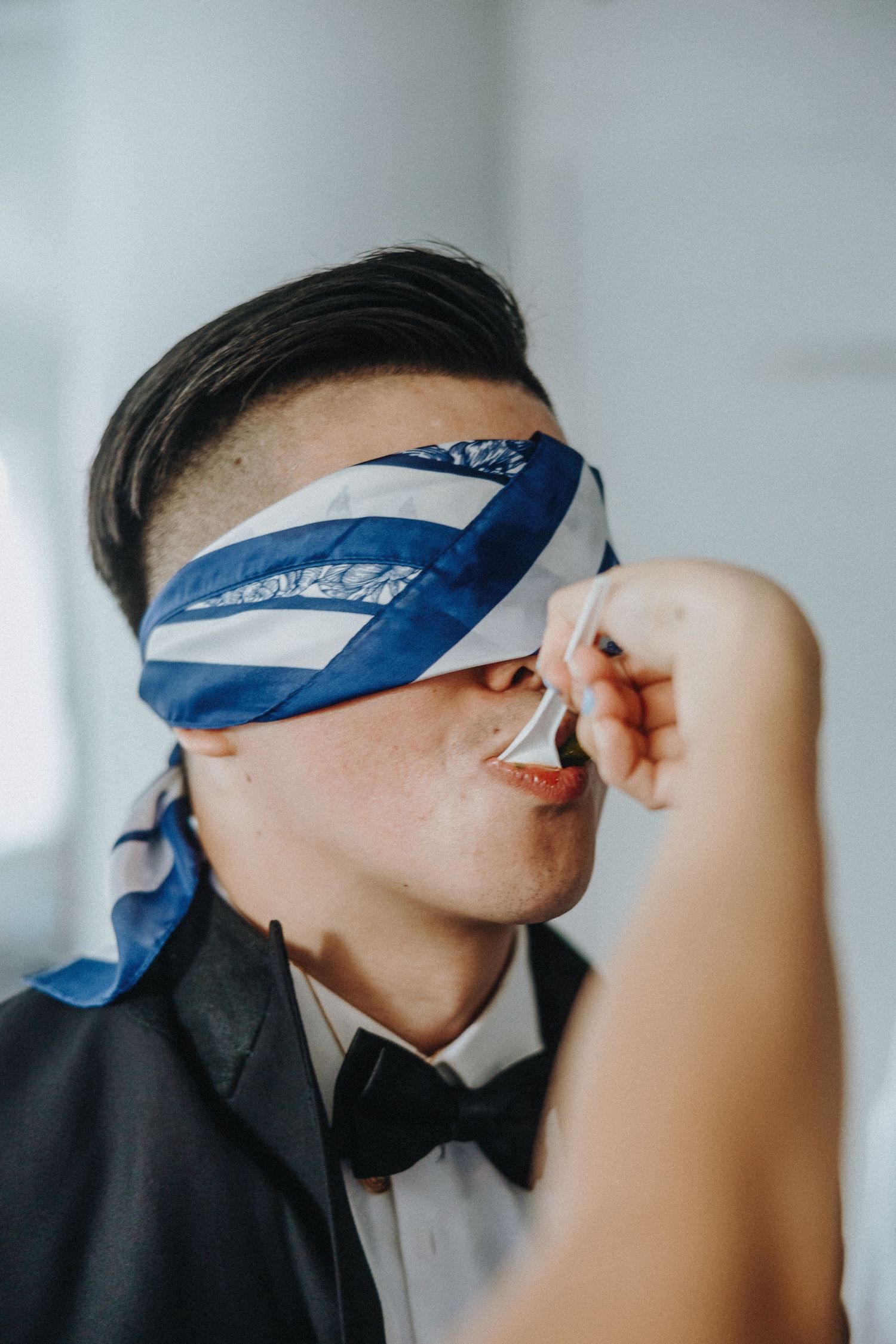 A series of images showing a person wearing a blue blindfold in a light interior setting.