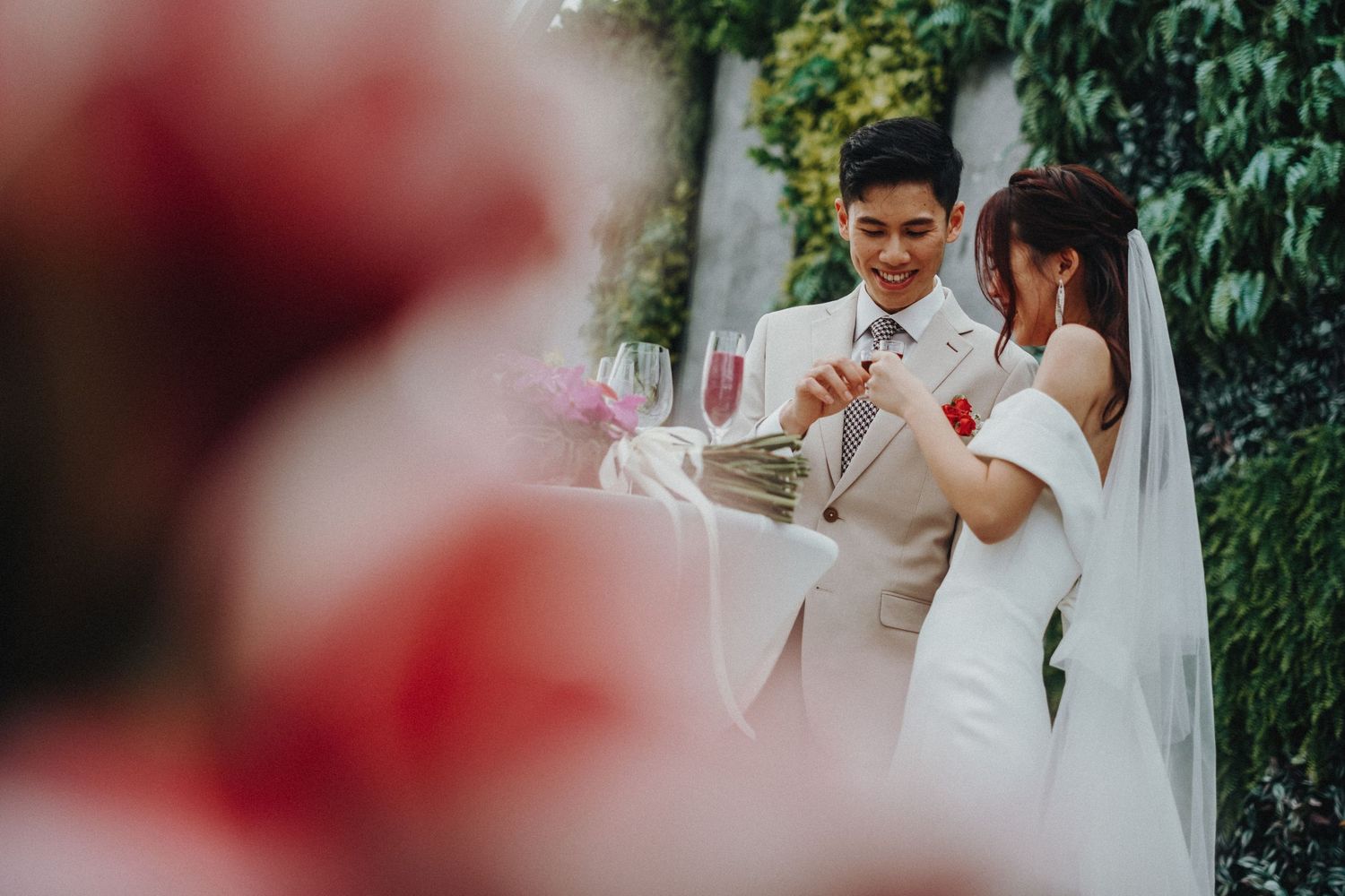 Bride and groom in tender emotional moment during outdoor wedding ceremony surrounded by greenery and natural light.