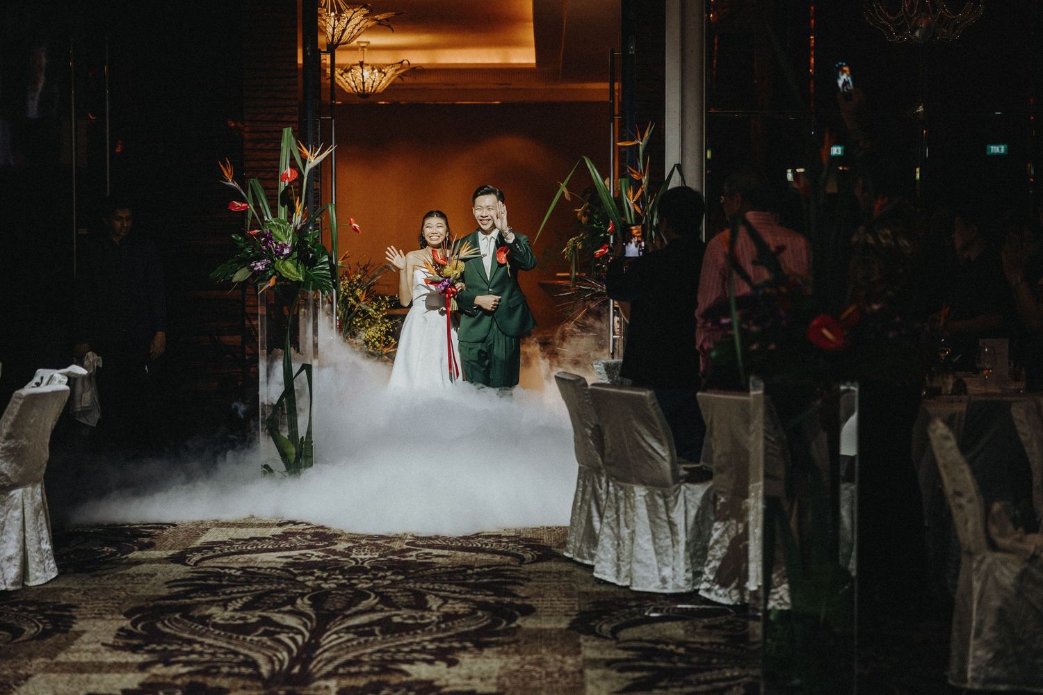 Dark and moody wedding venue lit with warm glowing lights creating a dramatic atmosphere.