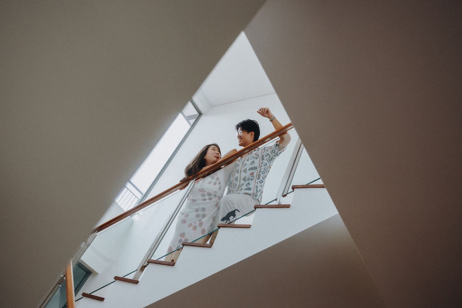 Creative angle shot through triangular space showing two people sitting on stairs.