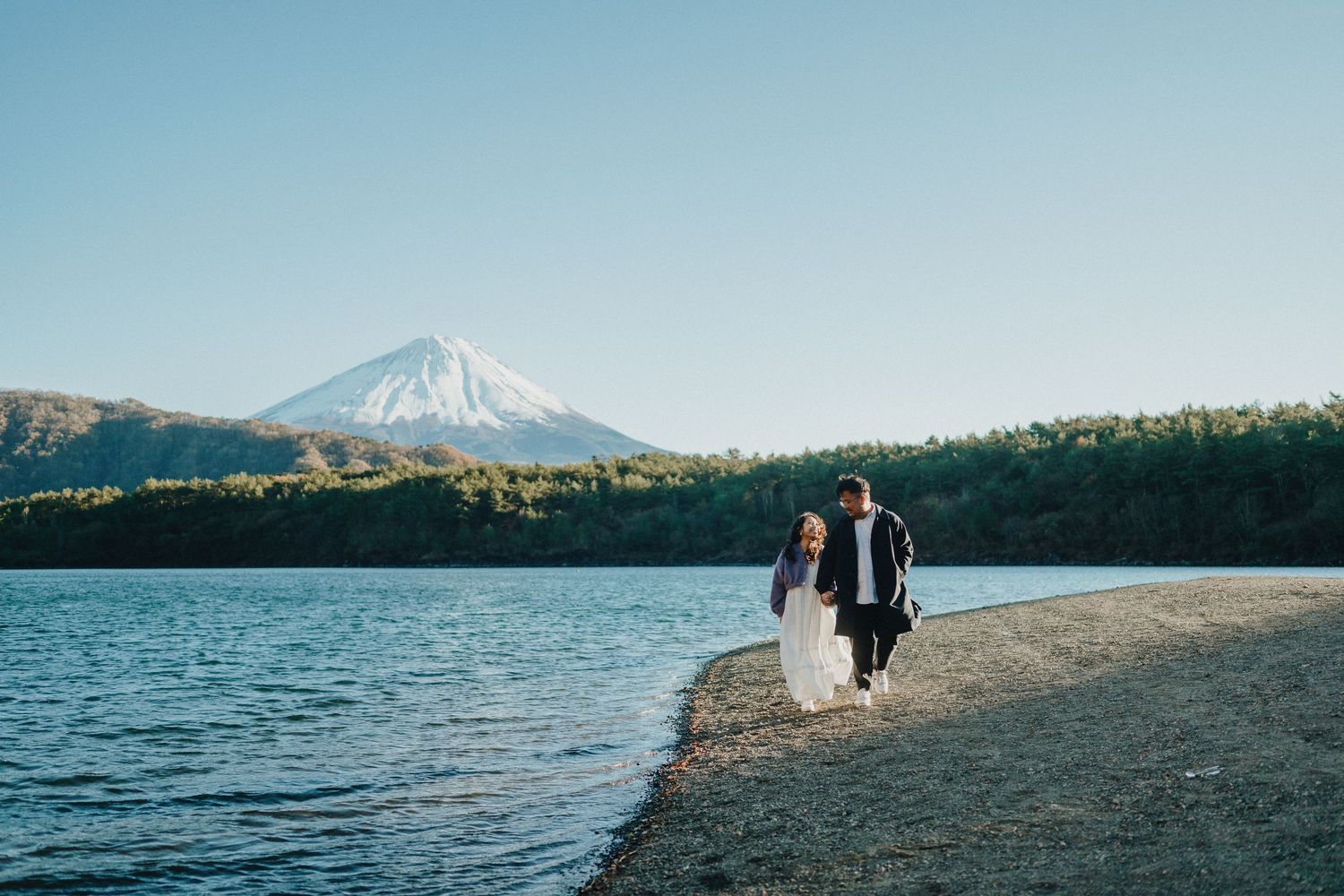 Scenic mountain lake view with snow-capped Mount Fuji dominating the landscape.