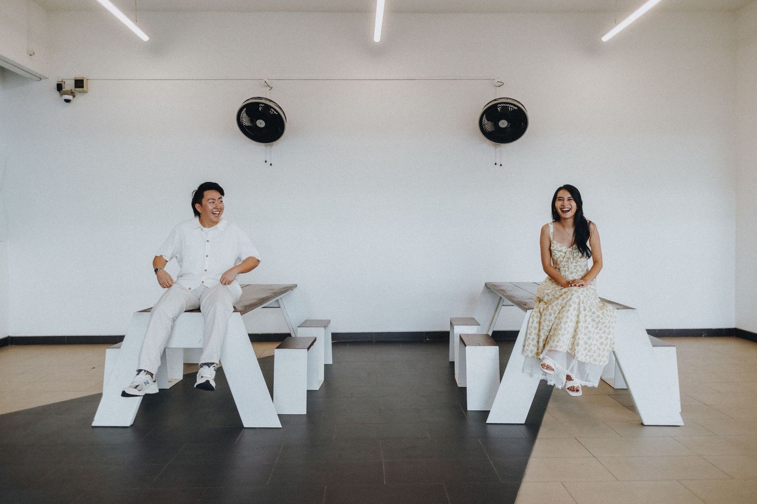 Minimalist white room with geometric architectural elements and fluorescent lighting.