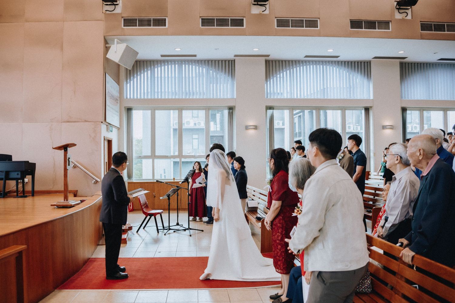 Bride walks down church aisle toward groom during traditional wedding ceremony.