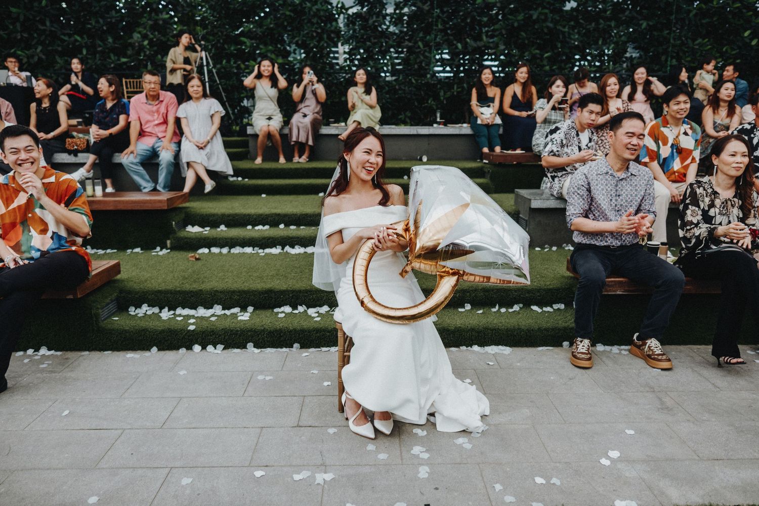 Wedding celebration with dancing and musical performance on tiered outdoor steps surrounded by guests.