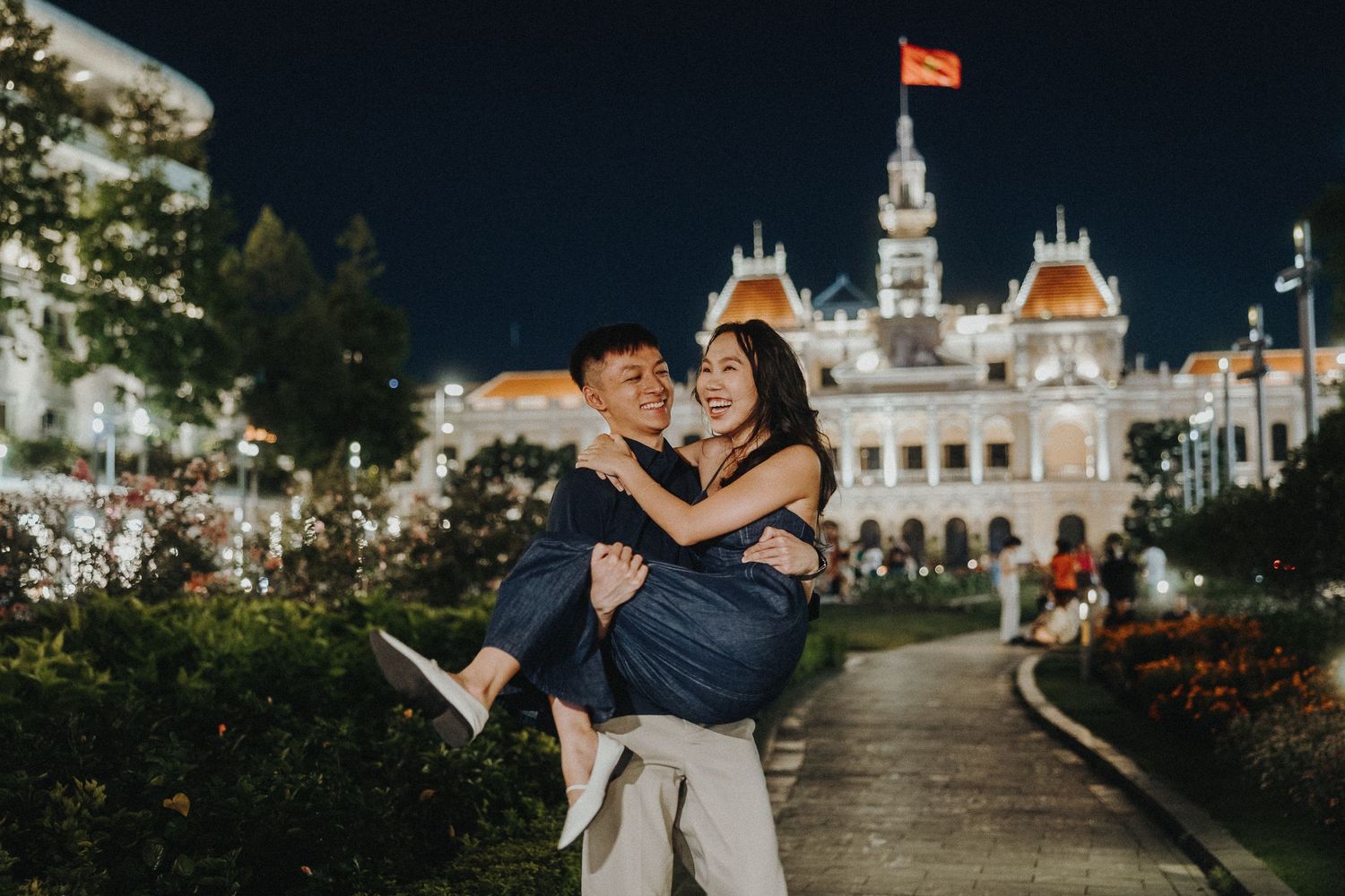 A serene nighttime view of Ho Chi Minh City Hall illuminated against a dark sky with decorative elements.