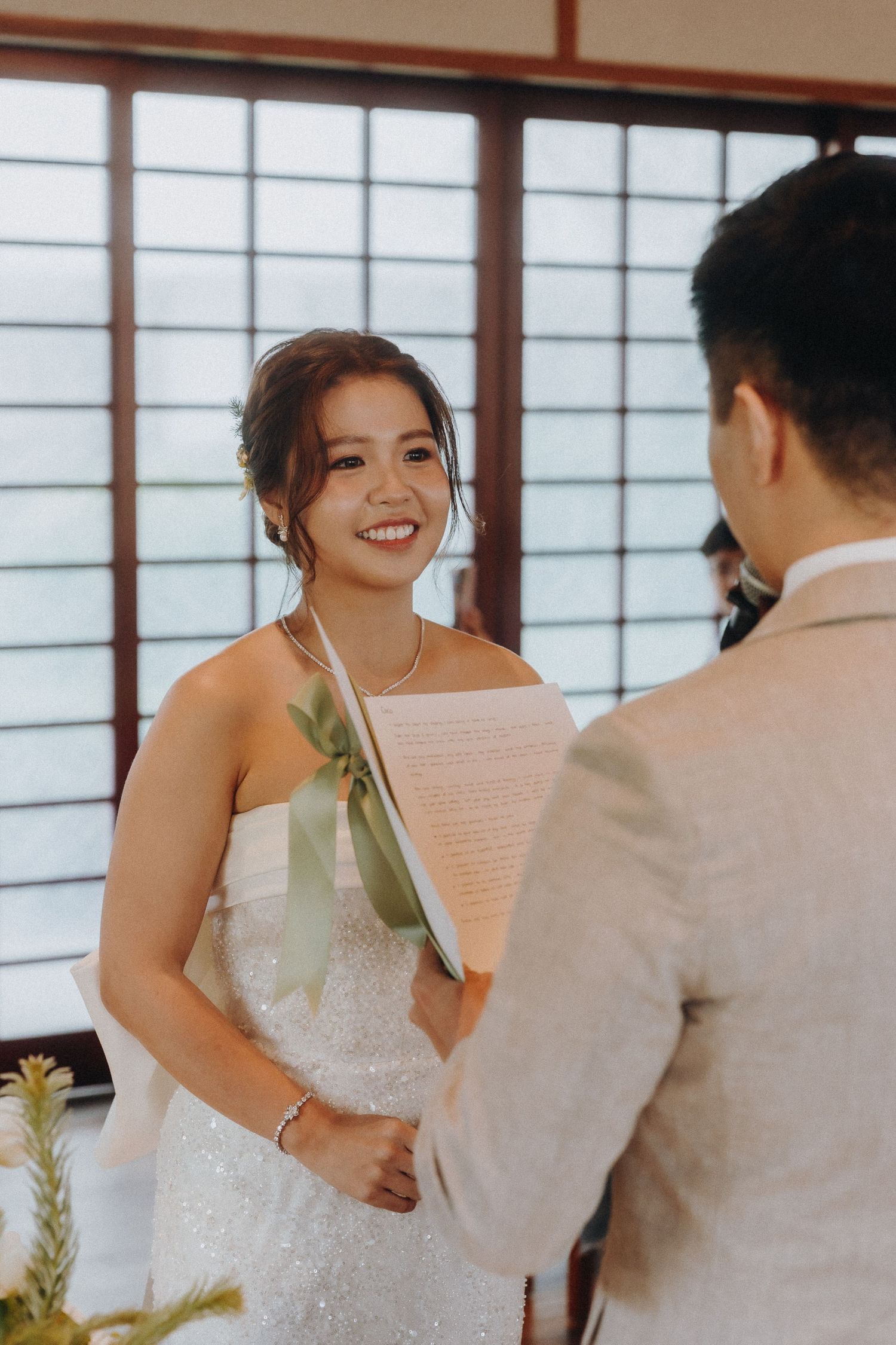 A couple shares a special moment during their wedding ceremony in a traditional Japanese room.
