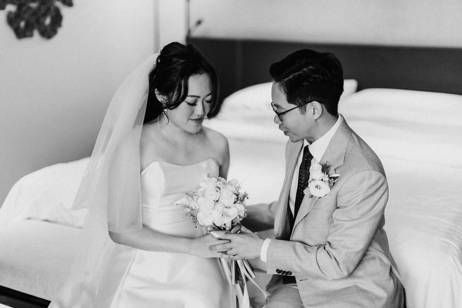Black and white wedding photo showing tender moments between newlyweds.