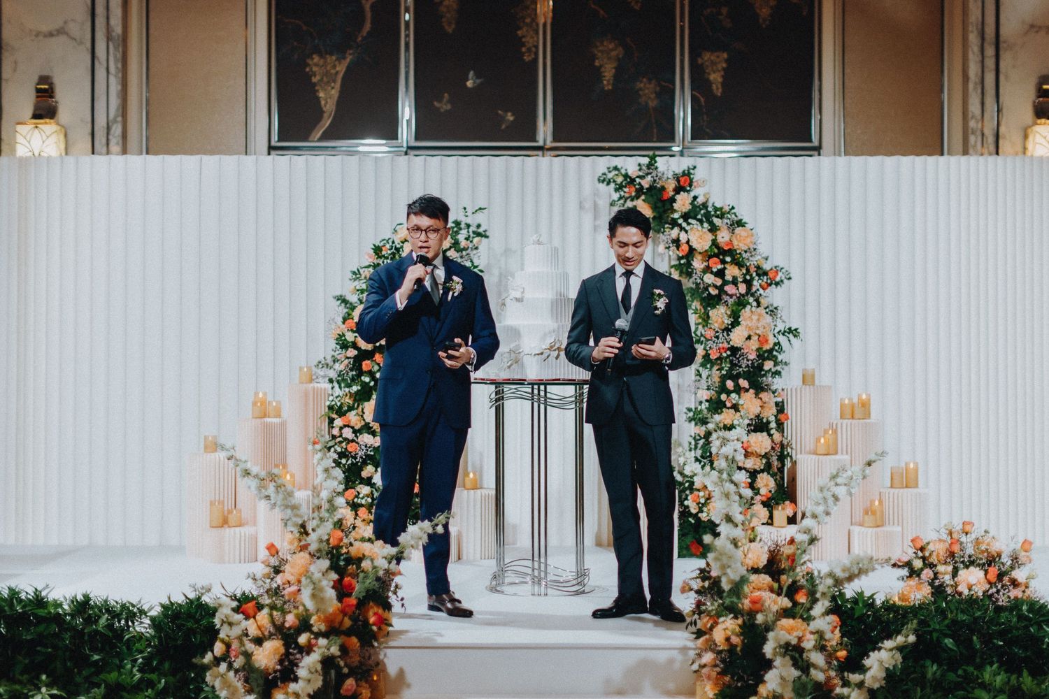 Modern wedding venue features elegant white panels and stunning floral arrangements.
