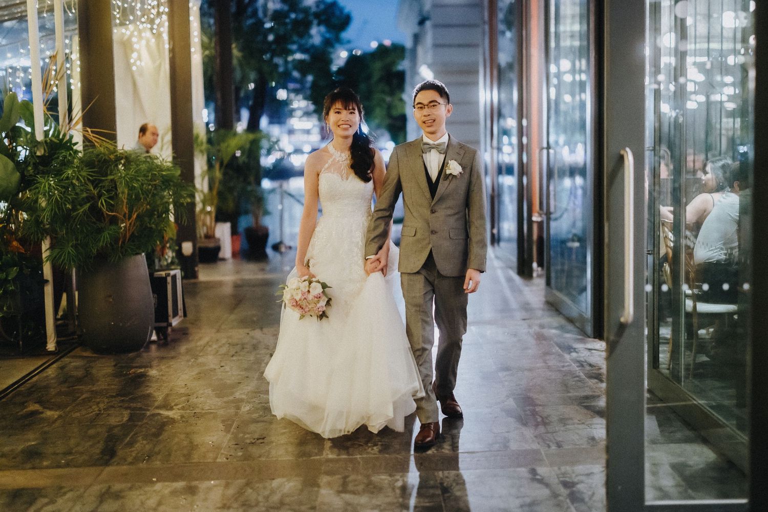 Wedding portraits taken in modern indoor venue with glass walls and natural lighting.